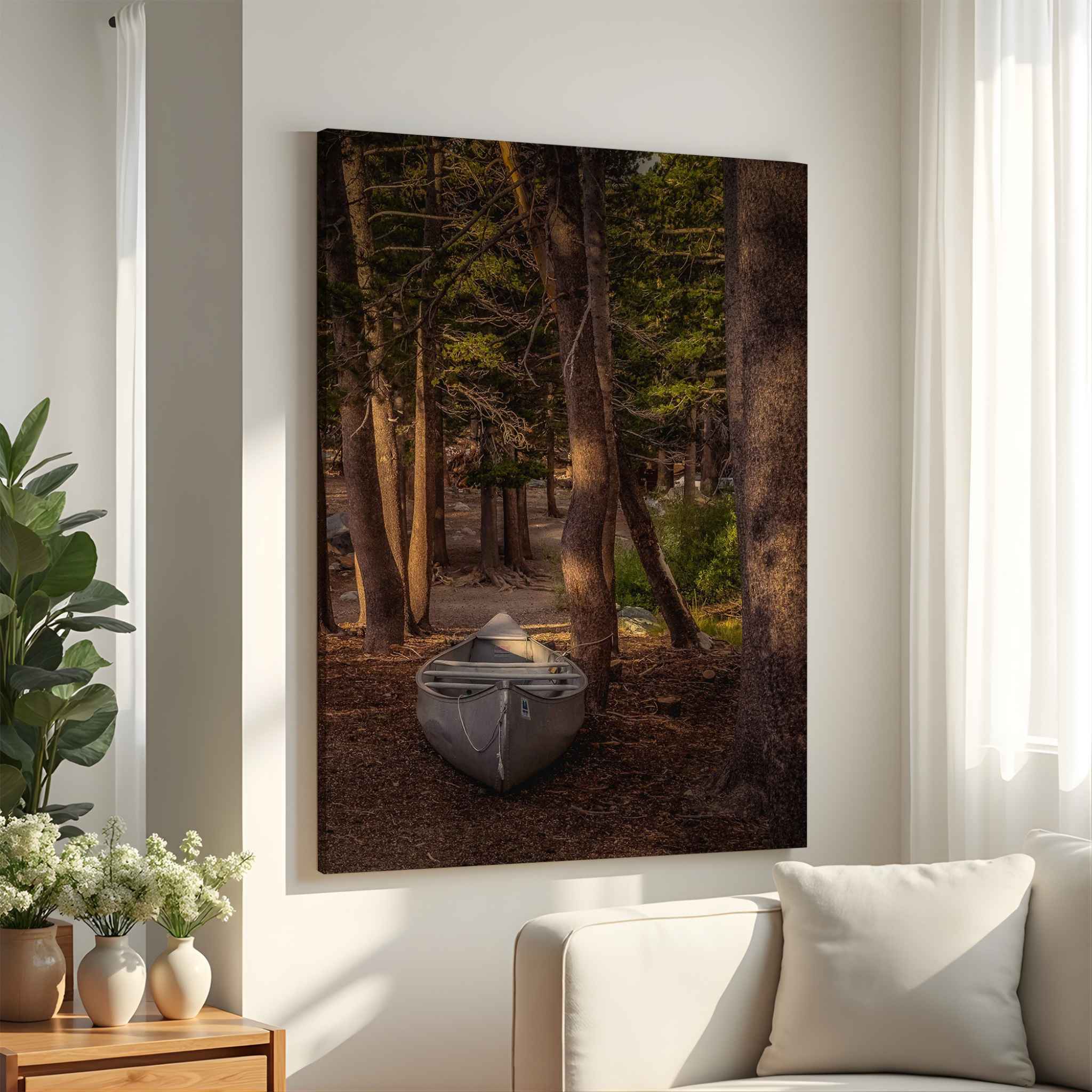 Waiting for a Boat gallery-wrapped canvas featuring a solitary canoe resting among the forest trees of the Eastern Sierra, California, displayed in a bright neutral living room.