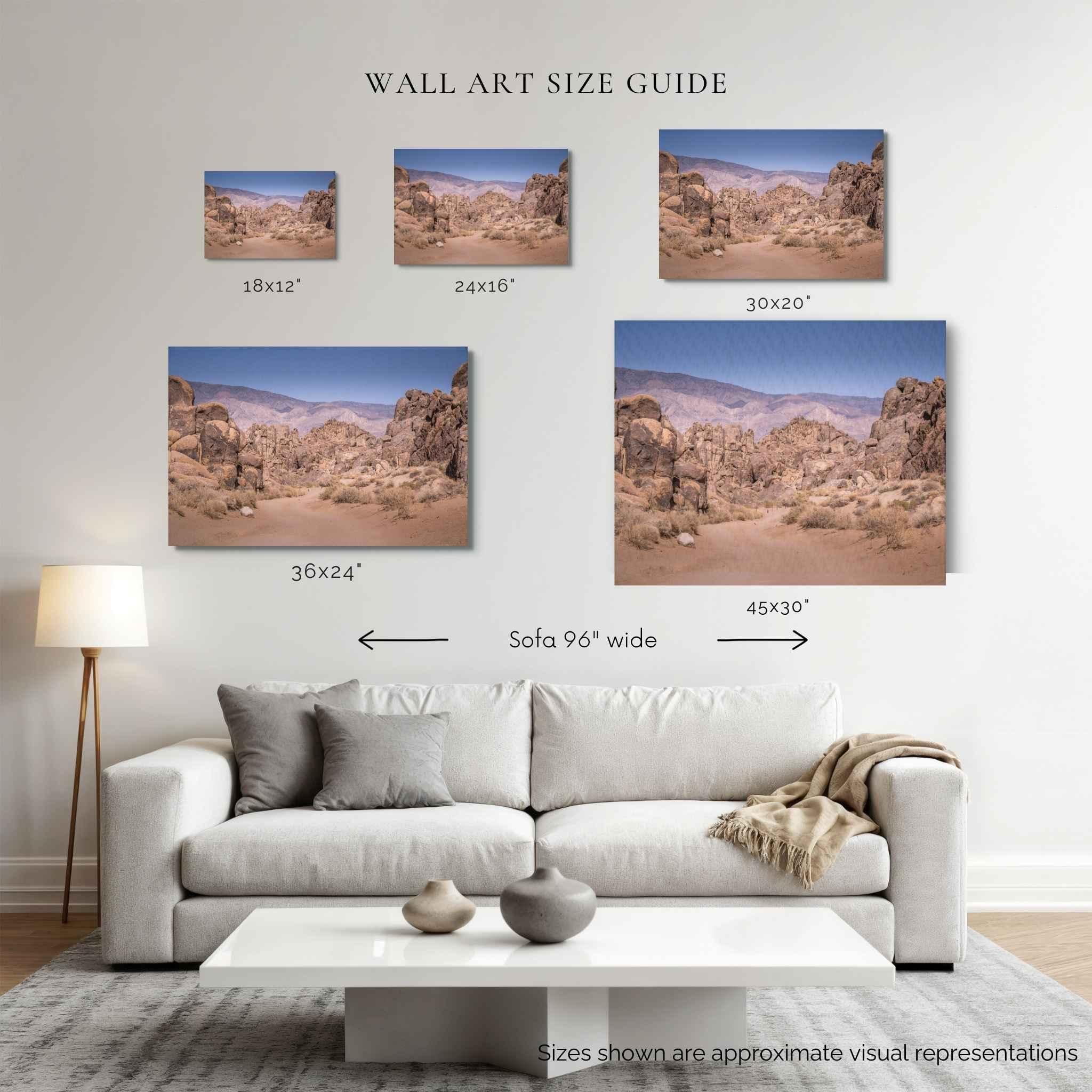 A wall art size guide showing five desert landscape canvas prints mounted above a white sofa in a living room. The image includes size labels for each print: 18x12", 24x16", 30x20", 36x24", and 45x30", plus a note that sizes are approximate visual representations.