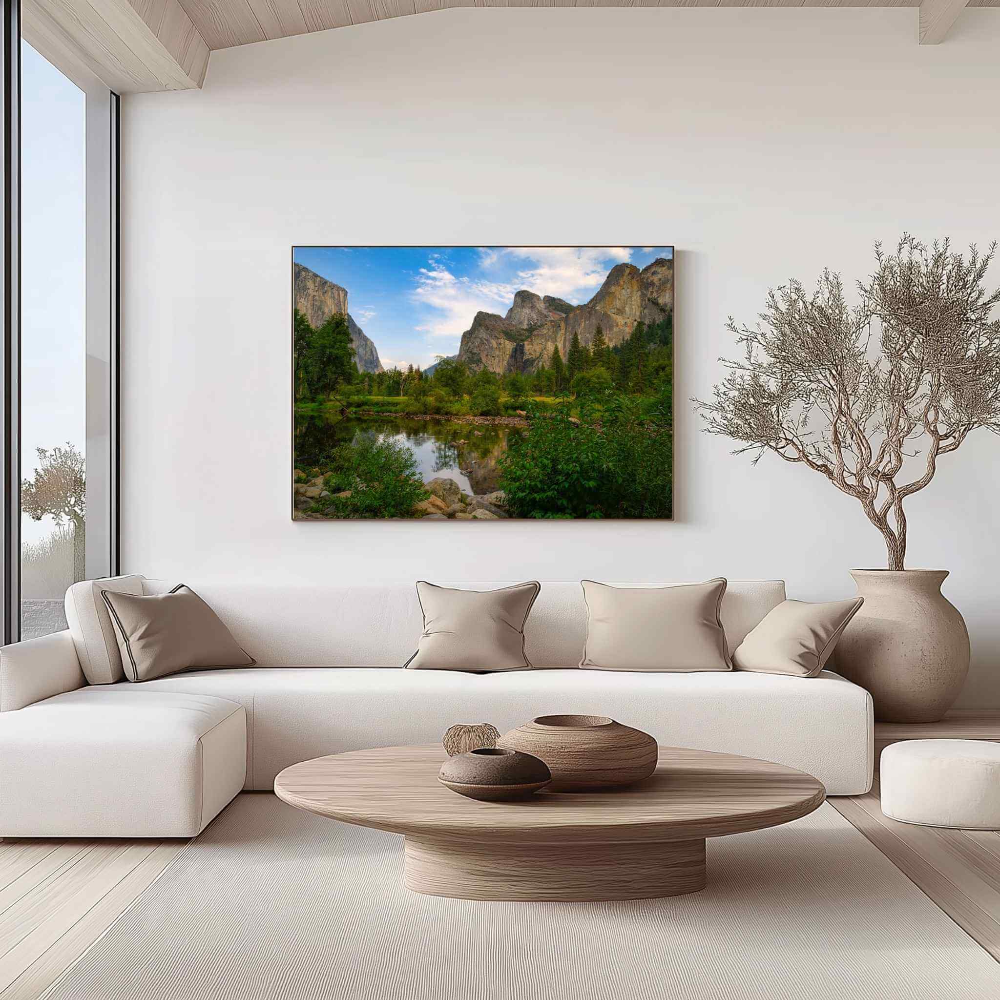 Large gallery-wrapped canvas featuring A Majestic Day in Yosemite Valley displayed above a cream sofa in a modern organic living room, showcasing Yosemite National Park's granite cliffs, peaceful river reflections, and lush green meadows in California by Abigail Diane Photography.