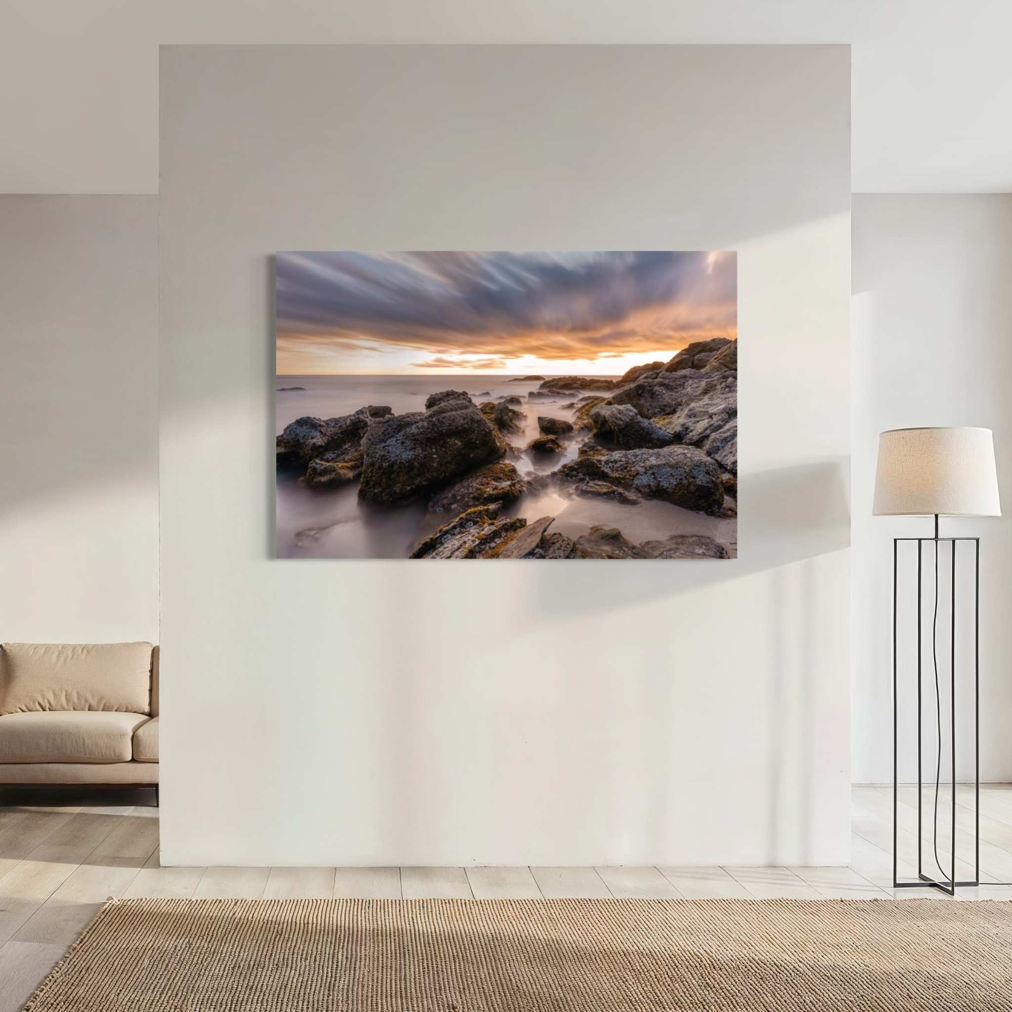 After the Storm dye-sublimation metal print by Abigail Diane Photography displayed on a minimalist feature wall, highlighting dramatic sunset clouds, smooth ocean water, and rugged rock formations photographed at Laguna Beach, California.