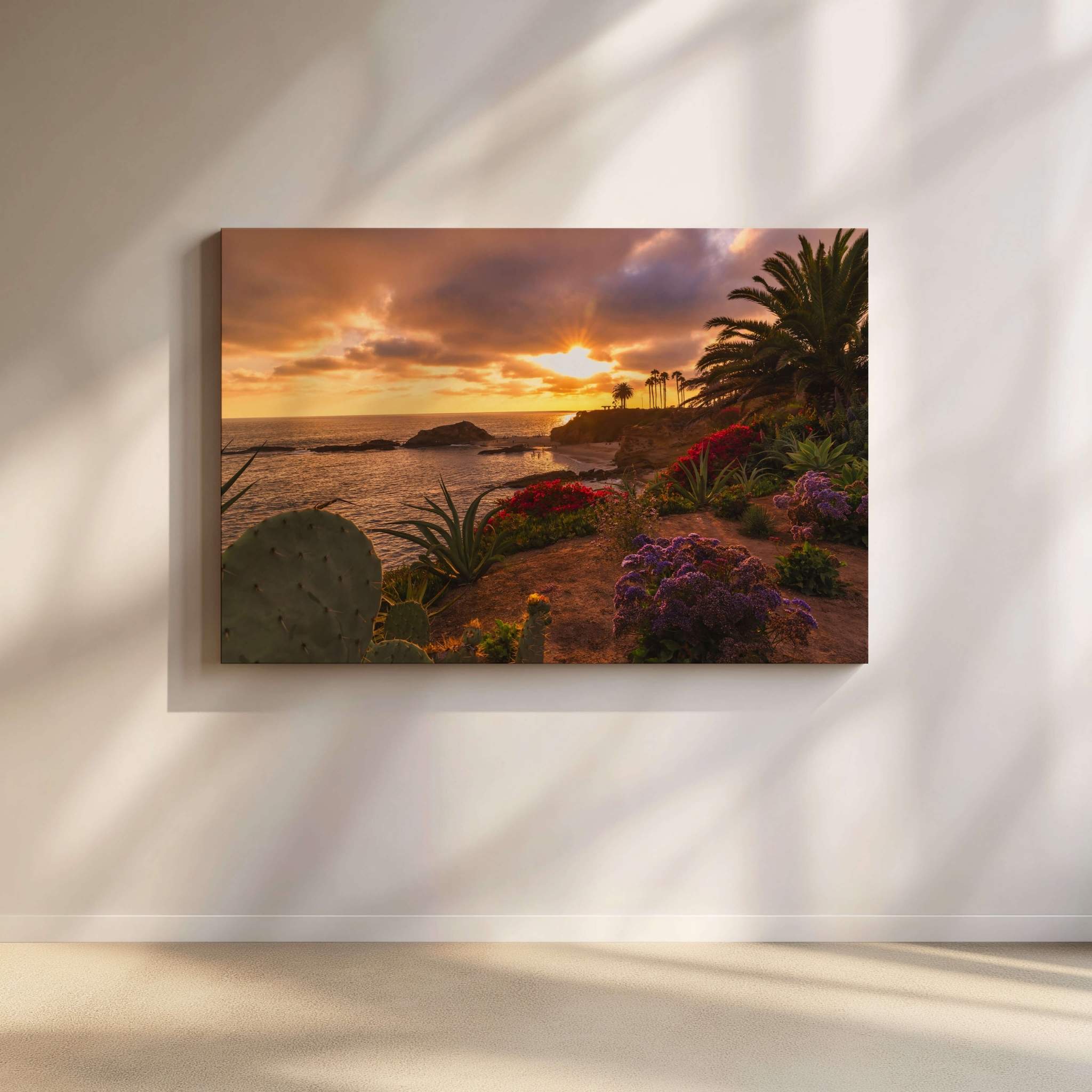 Gallery wrapped canvas of Basking in the Golden Sunset displayed on a modern wall, featuring a golden sunset over Heisler Park in Laguna Beach, California, with vibrant coastal flowers, palm trees, and the Pacific Ocean. Fine art by Abigail Diane Photography.