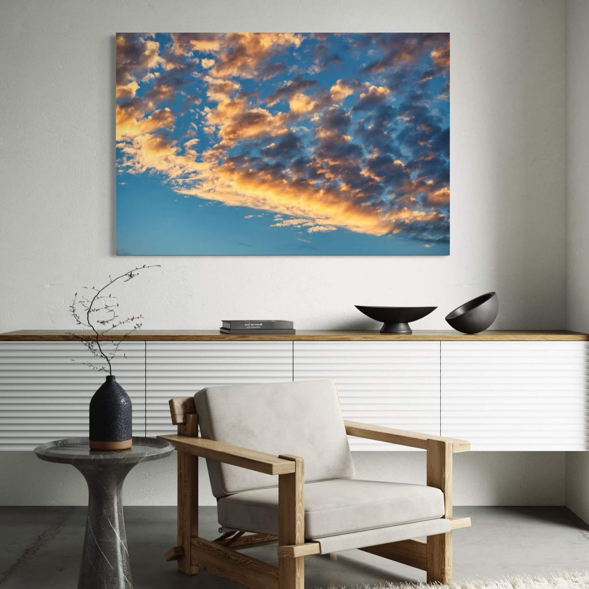 Blue and Gold Symphony canvas wall art featuring glowing golden clouds against a rich blue sky, displayed above a modern neutral chair in a contemporary interior.