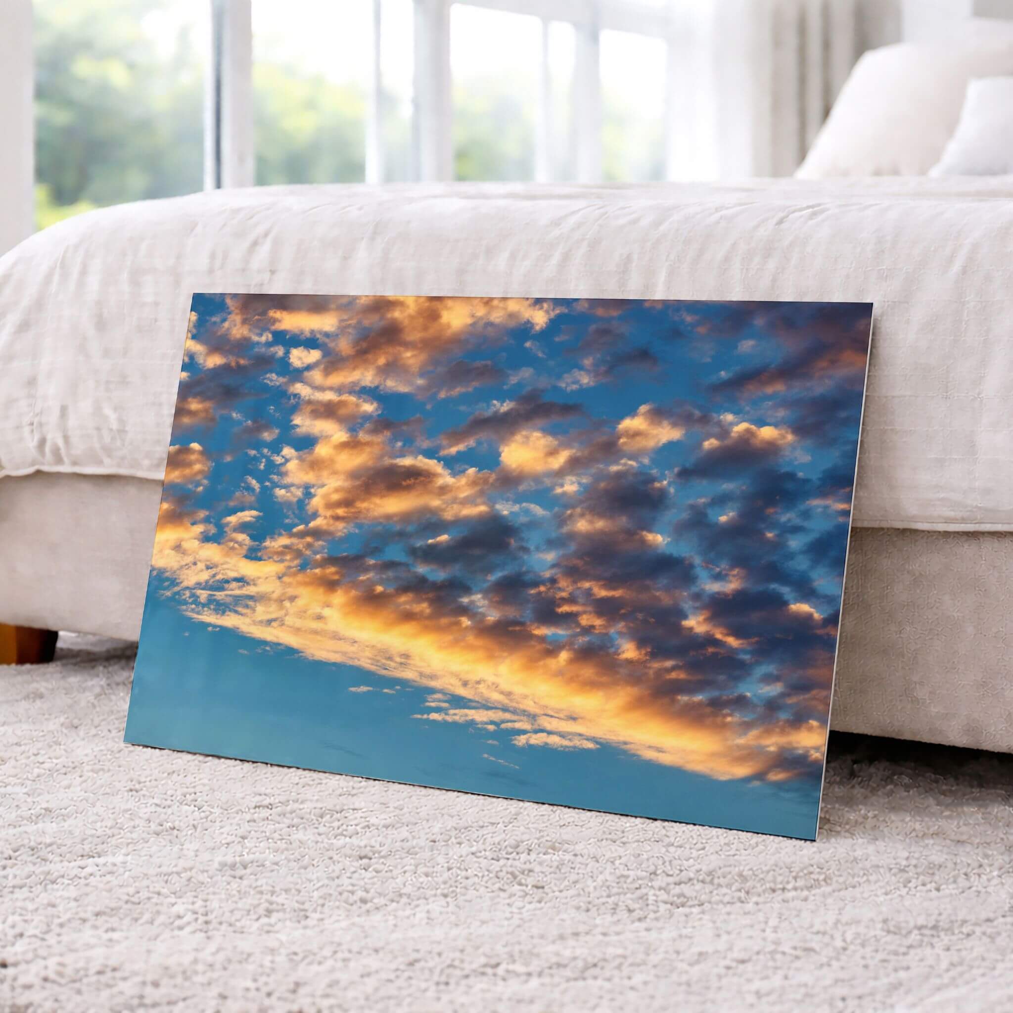 Blue and Gold Symphony dye-sublimation metal print displayed in a light neutral bedroom, showcasing the vivid blue sky and luminous golden clouds. Photograph by Abigail Diane Photography.