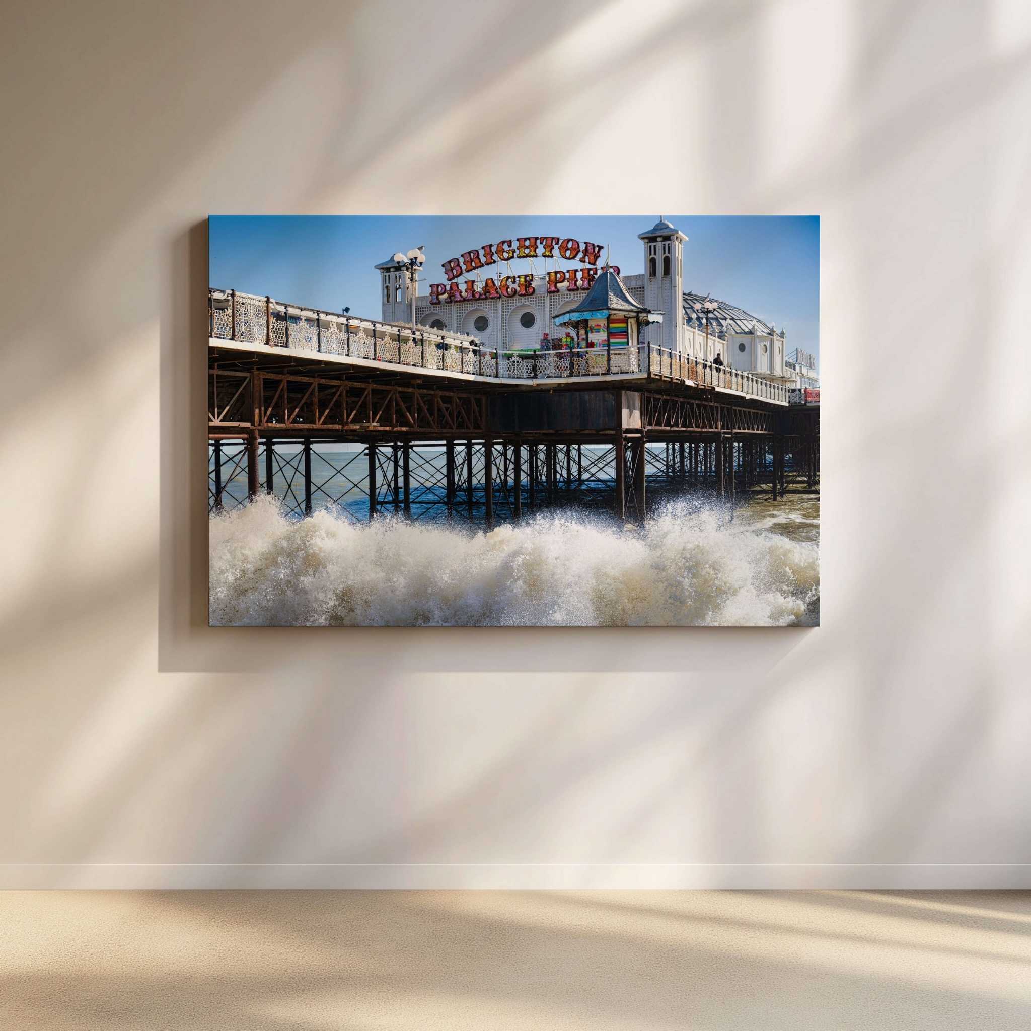 Brighton Palace Pier gallery-wrapped canvas by Abigail Diane Photography displayed in a contemporary minimalist living room, showcasing waves crashing beneath the iconic Brighton Palace Pier on England's south coast under a clear blue sky, bringing timeless British coastal charm to the space.