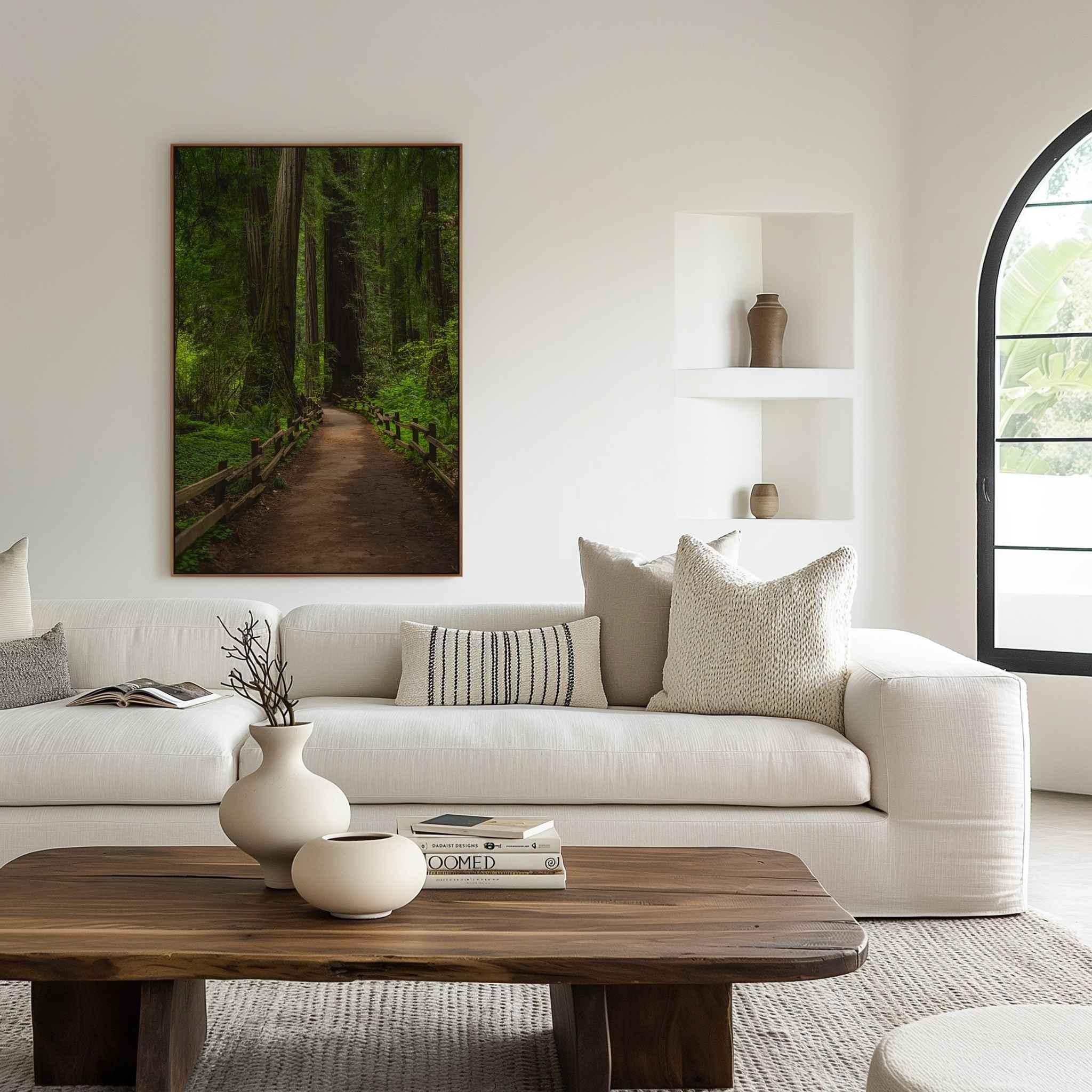 Large framed Cathedral of Giants photography print showcasing an ancient redwood forest trail in Muir Woods California, styled above a contemporary cream sofa in a serene living room designed to inspire calm and connection with nature by Abigail Diane Photography.