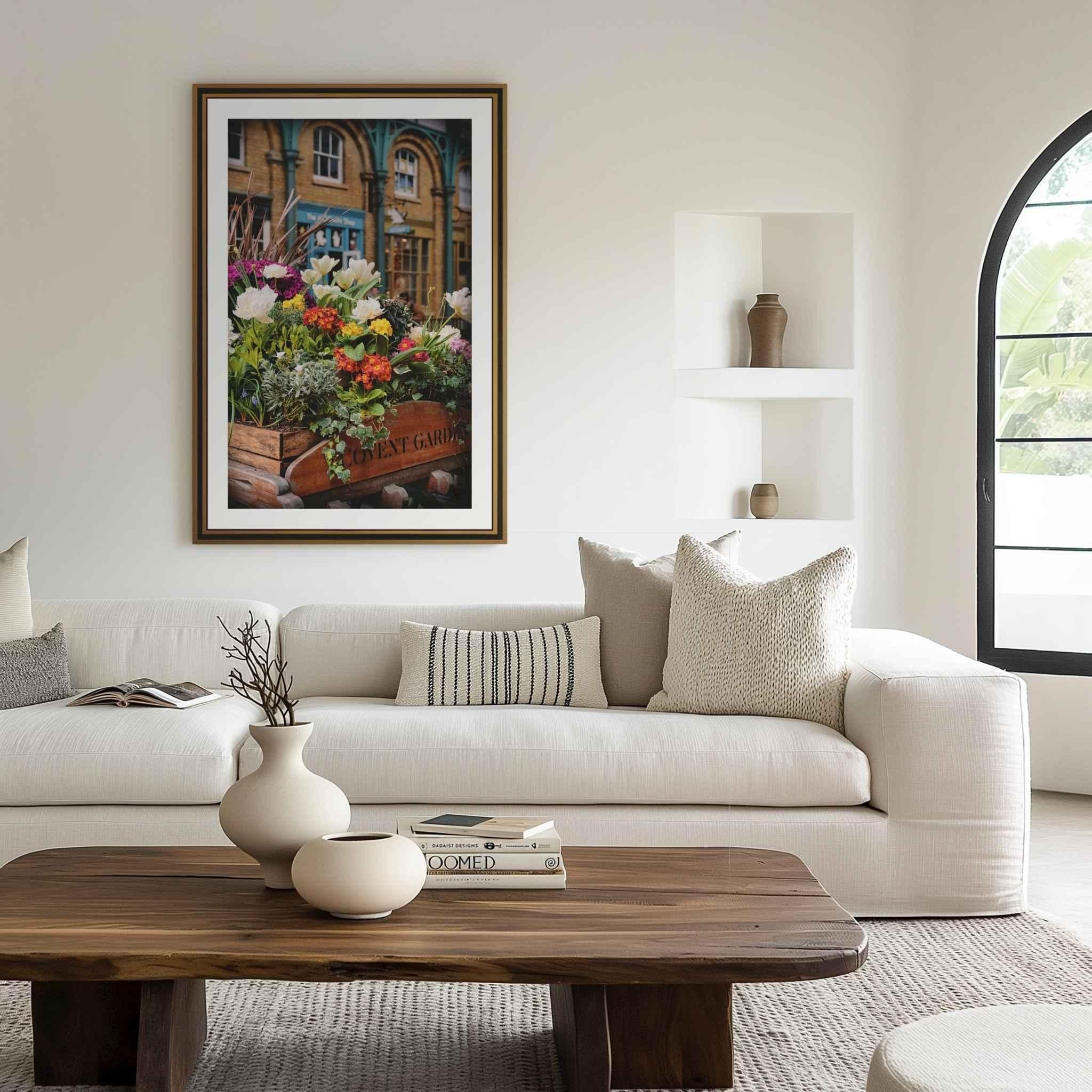 Framed fine art print of Covent Garden in Bloom by Abigail Diane Photography displayed above a neutral sofa in a contemporary living room. The artwork showcases vibrant spring flowers in Covent Garden, London, adding color and warmth to the elegant interior.