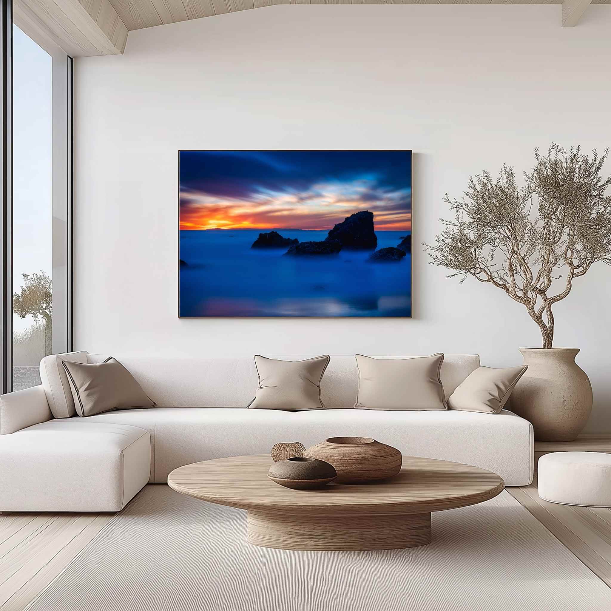 Gallery wrapped canvas of Escape to a Mystical Blue Hour displayed above a contemporary sofa, featuring a tranquil blue hour seascape with dramatic rocks along the Laguna Beach coastline, California. Fine art wall decor by Abigail Diane Photography.