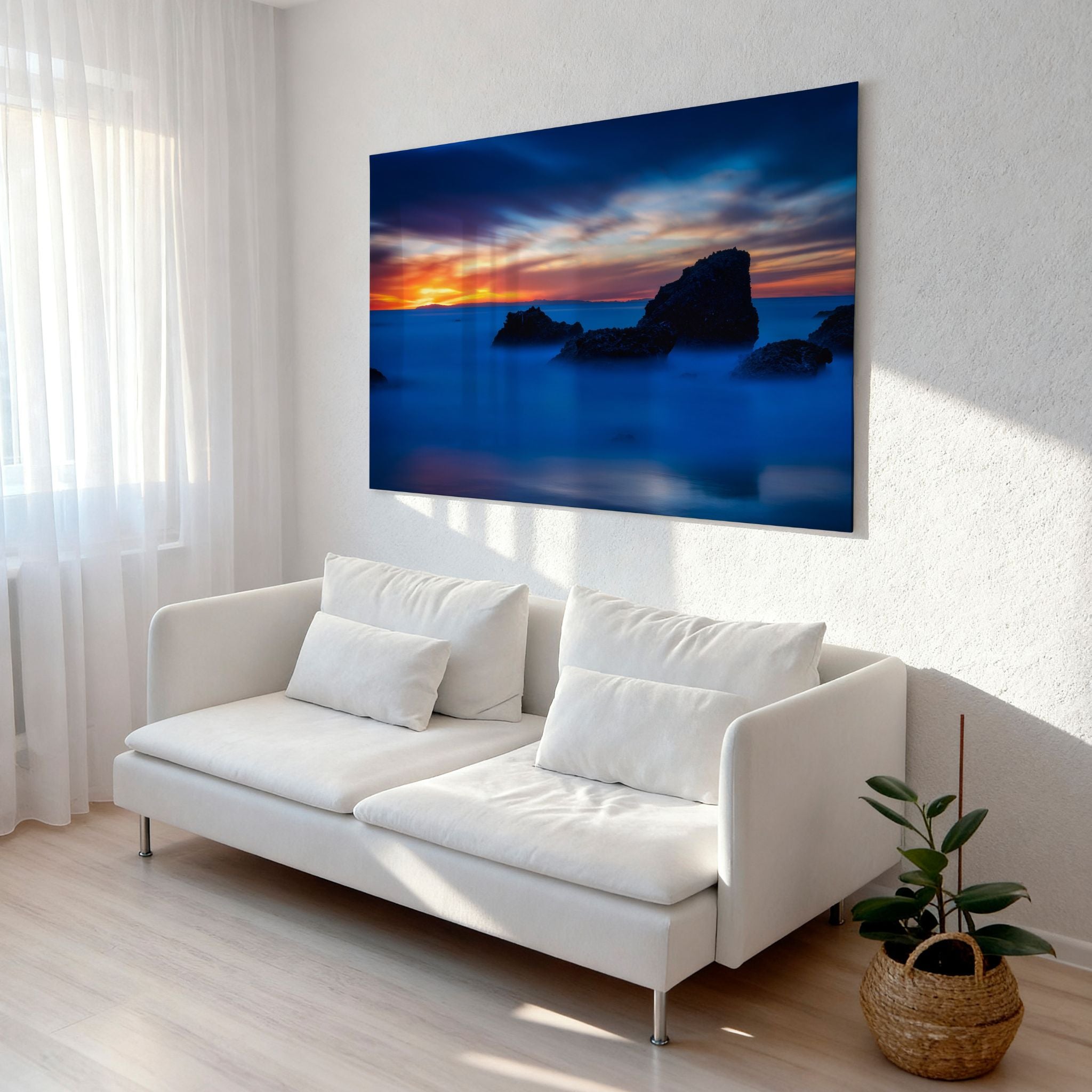Escape to a Mystical Blue Hour high-definition metal print displayed above a modern white sofa in a bright contemporary living room, showcasing a tranquil blue-hour Laguna Beach sunset with glowing skies and smooth ocean water.