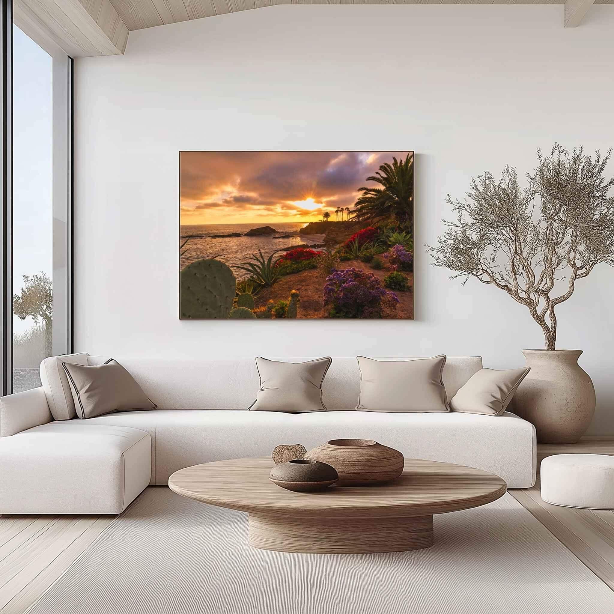 Large gallery-wrapped canvas print of Gleaming Golden Sunset over Laguna Beach, California by Abigail Diane Photography displayed above a cream sectional sofa in a contemporary living room with warm neutral décor and natural light.