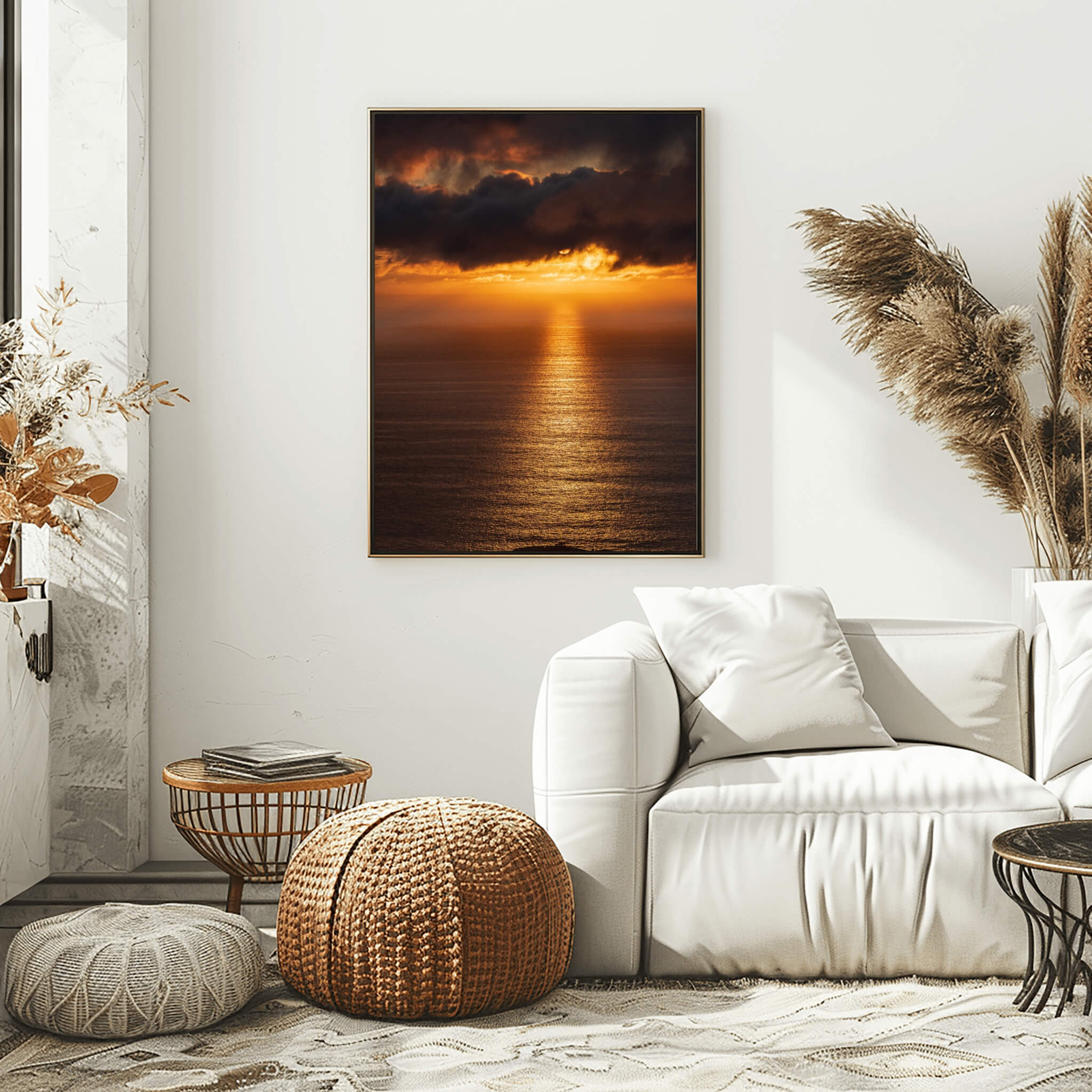 Golden Rays on the Mirrored Sea of the Pacific by Abigail Diane Photography, warm ocean sunset wall art in a neutral living room above a soft white sofa with textured cushions, woven pouf, rattan side tables and dried pampas grass creating a calm coastal atmosphere.