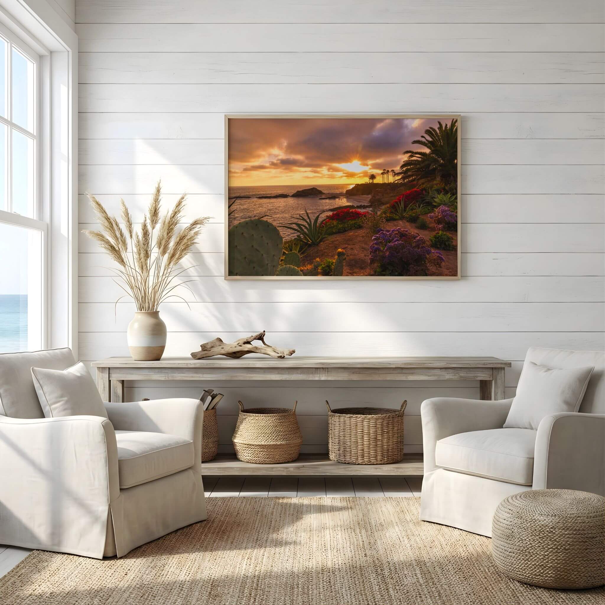 Laguna Beach coastal sunset wall art displayed above a console table in a bright coastal living room with natural textures and neutral décor.