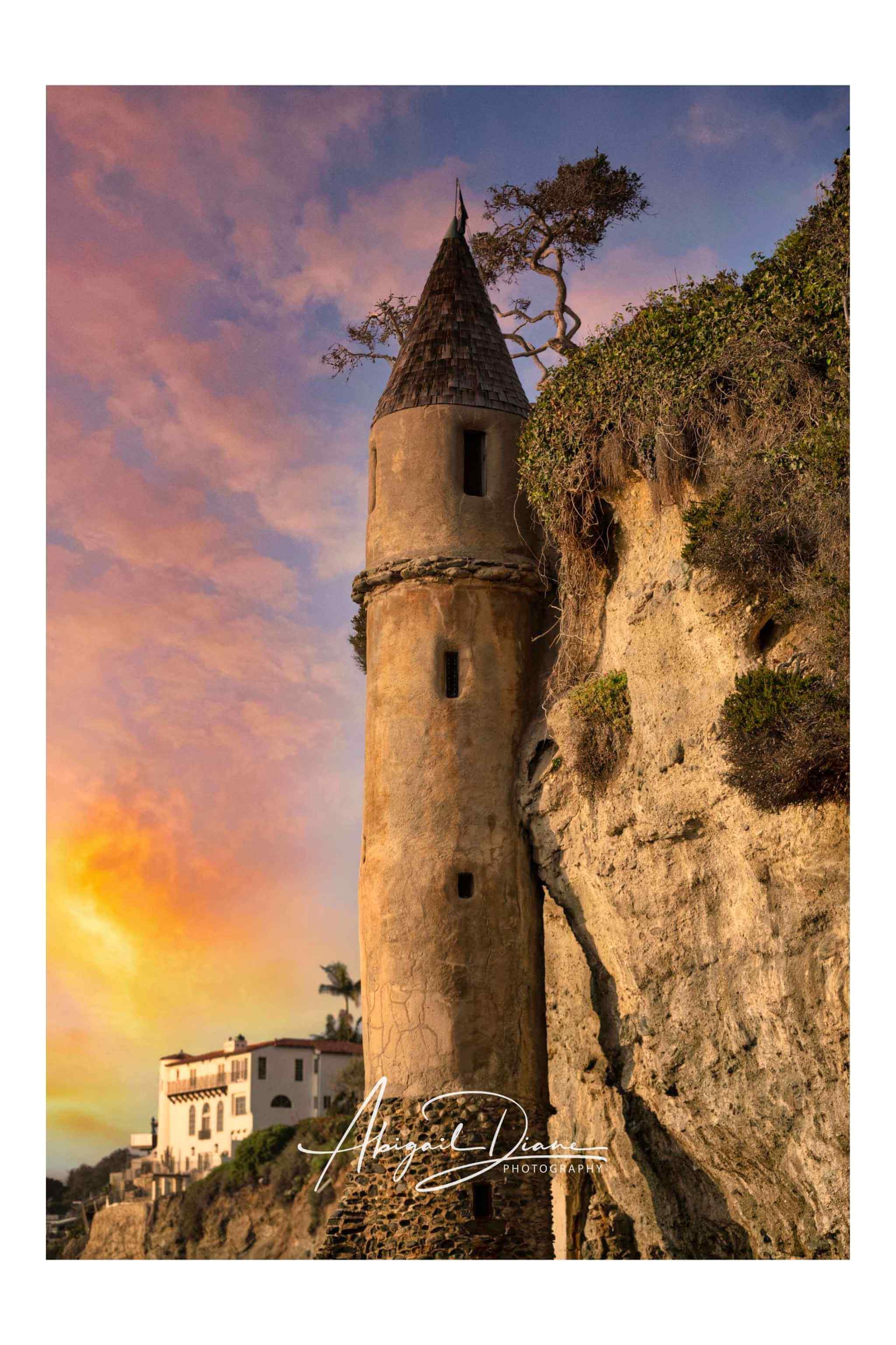 Sunset photograph of the historic Pirate Tower at Victoria Beach in Laguna Beach California featuring glowing pastel skies, rugged coastal cliffs, and the mysterious castle-like tower inspired by the story of Rapunzel, photographed by Abigail Diane Photography.
