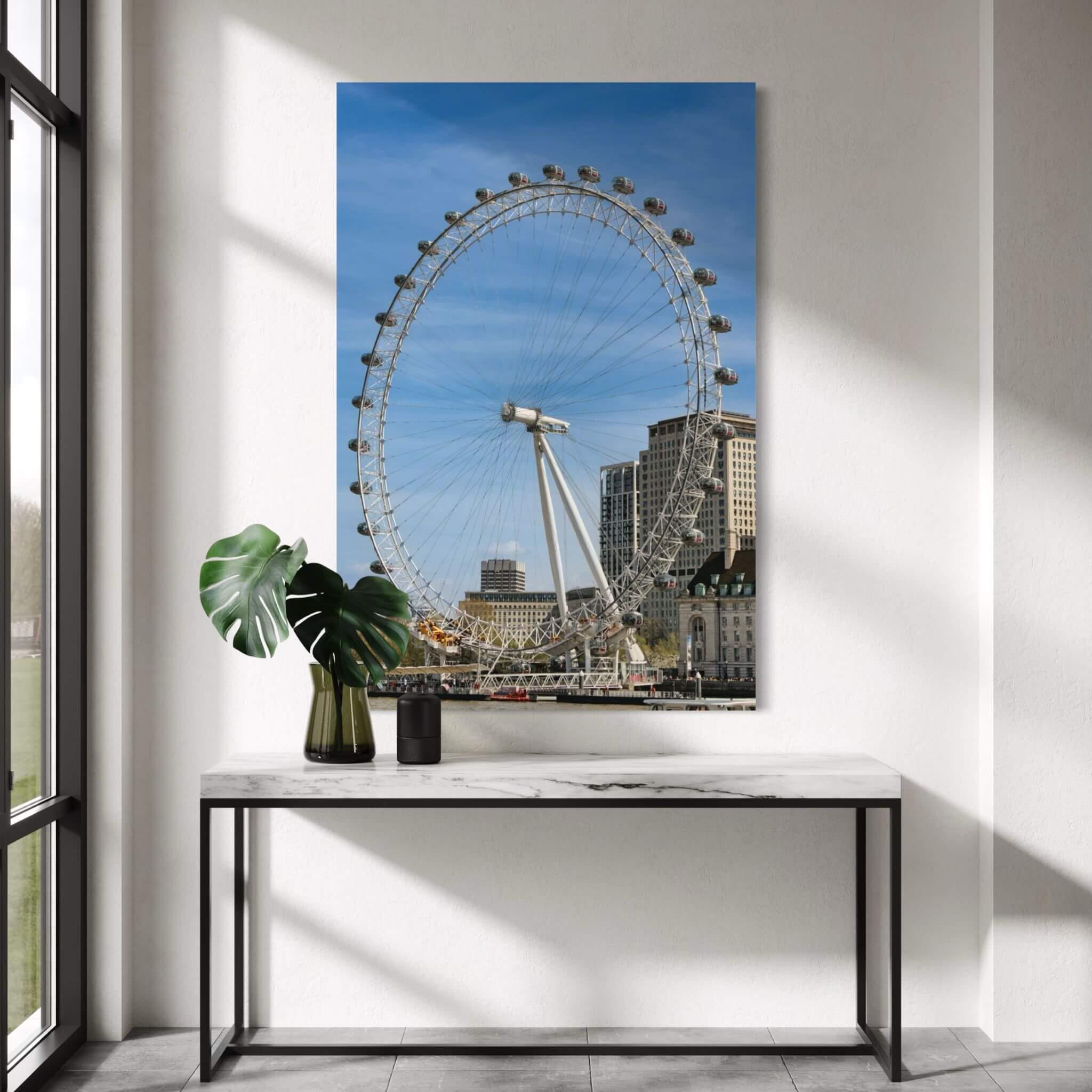 London Eye metal print displayed above a marble console table in a bright modern interior with natural light.