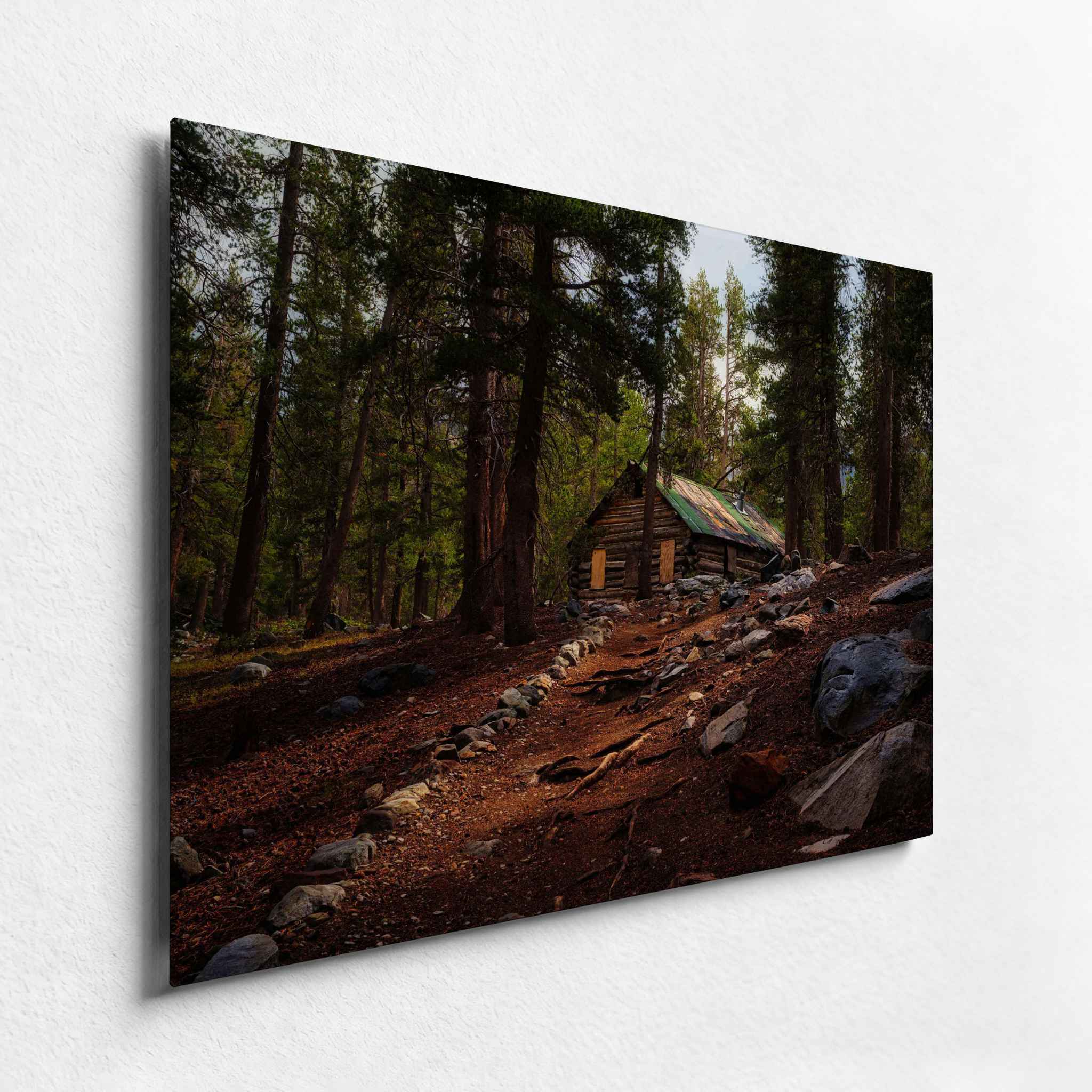 Rustic mountain cabin surrounded by pine forest in California’s Eastern Sierras, displayed as a frameless HD metal print from an angled side view.