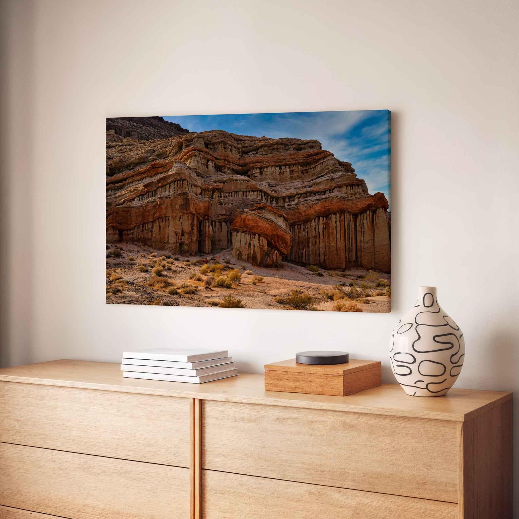 Sculpted by Time canvas print featuring layered desert rock formations at Red Rock Canyon State Park, California, displayed above a natural wood credenza.