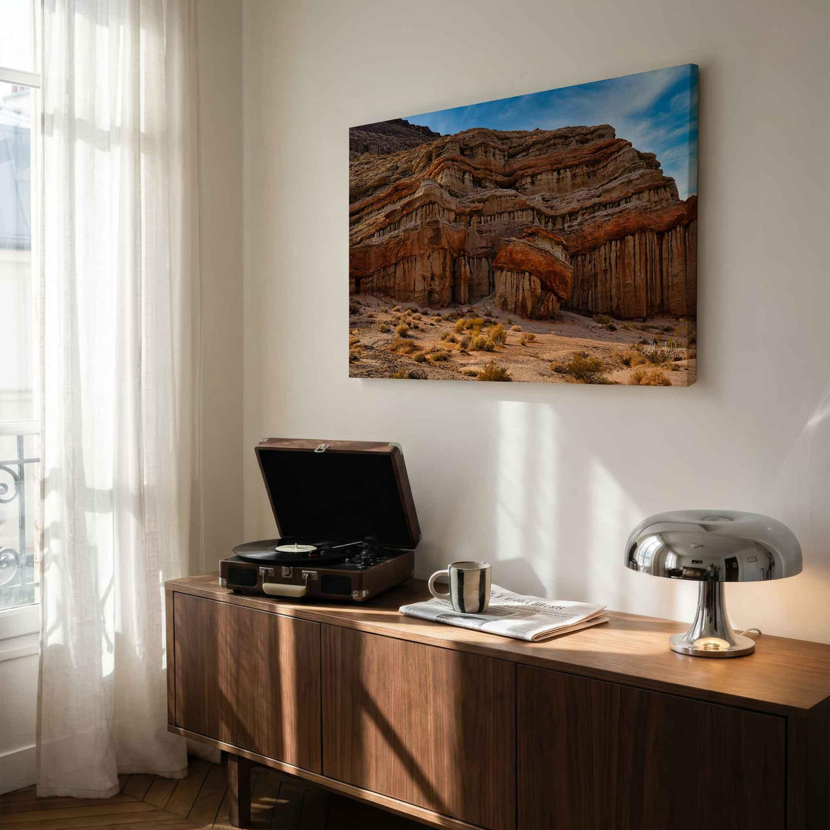Sculpted by Time metal print of the dramatic desert cliffs at Red Rock Canyon State Park, California, displayed above a wood console in a modern interior.
