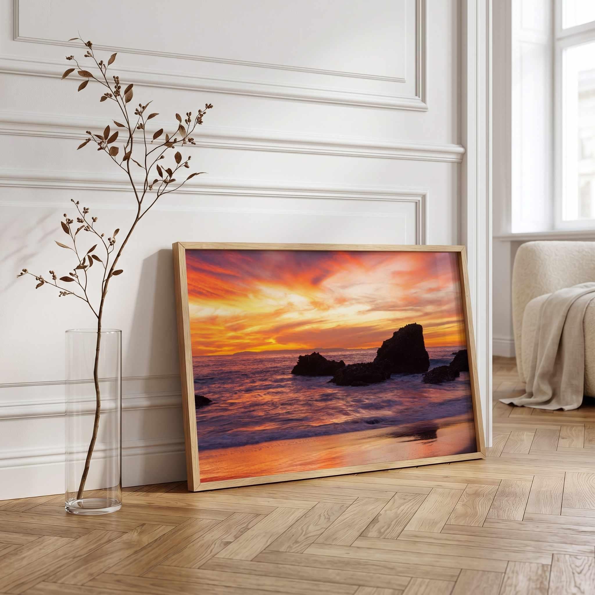 Framed Sherbet Sunset fine art print by Abigail Diane Photography leaning against a wall in a modern interior, featuring a vibrant Laguna Beach, California sunset reflected across the shoreline.