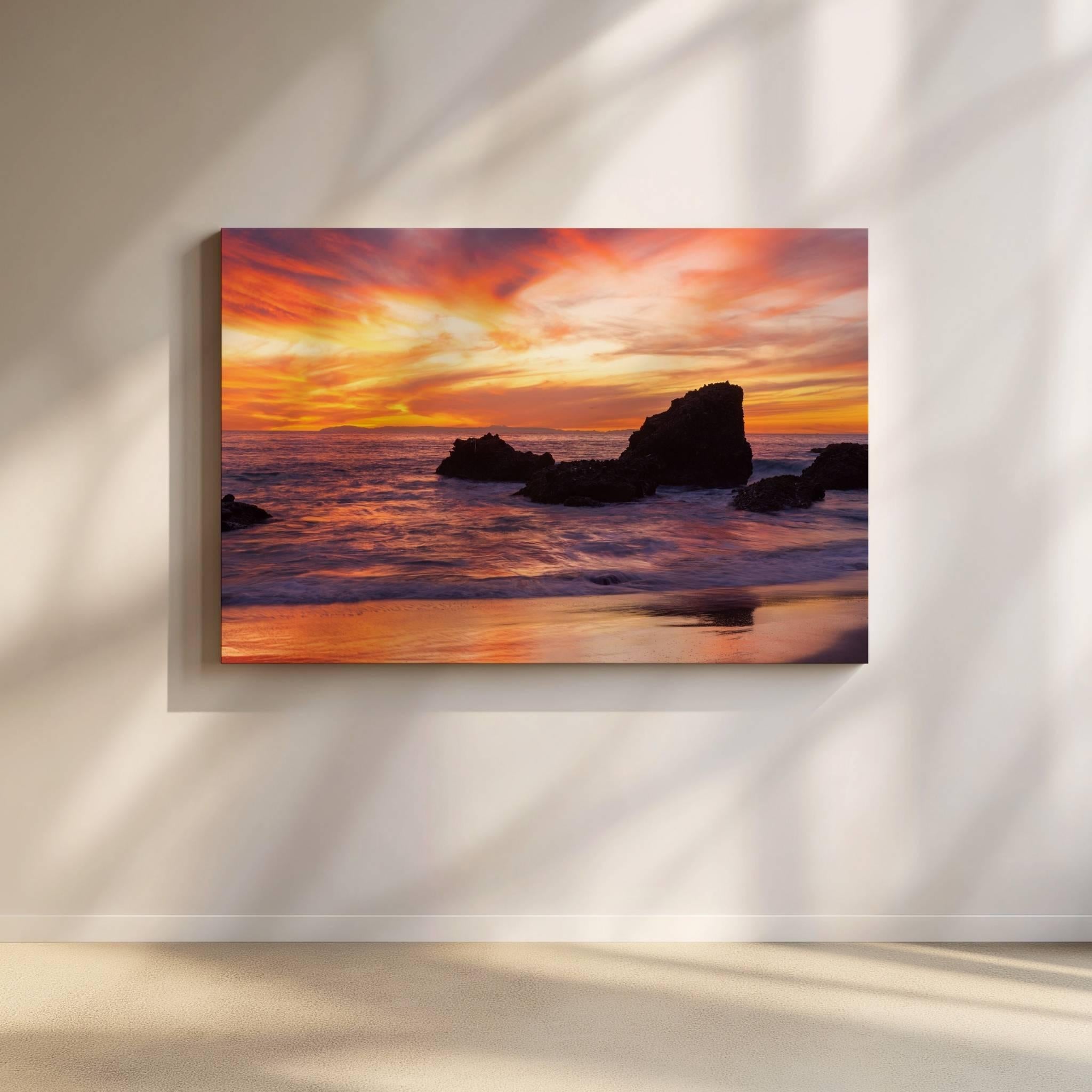 Sherbet Sunset gallery-wrapped canvas print displayed on a softly lit wall, featuring a vibrant Laguna Beach sunset with dramatic clouds, ocean waves, and rocky shoreline in California.