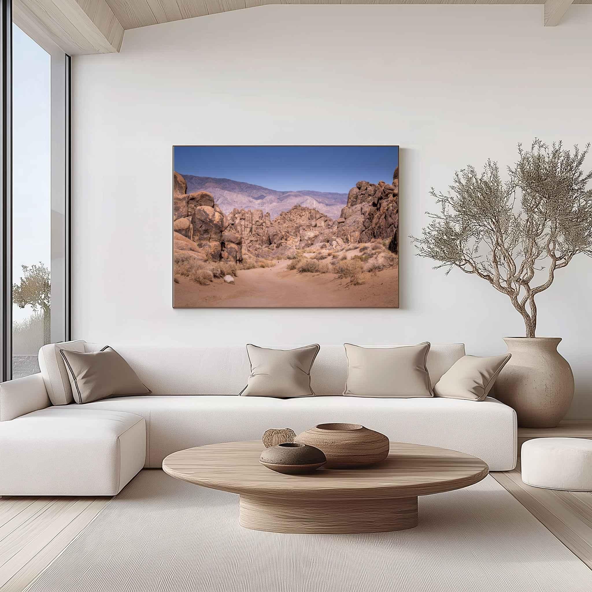 Sierra Desert Passage canvas print featuring the rugged Alabama Hills near Lone Pine, California, displayed above a neutral sofa in a warm contemporary living room.