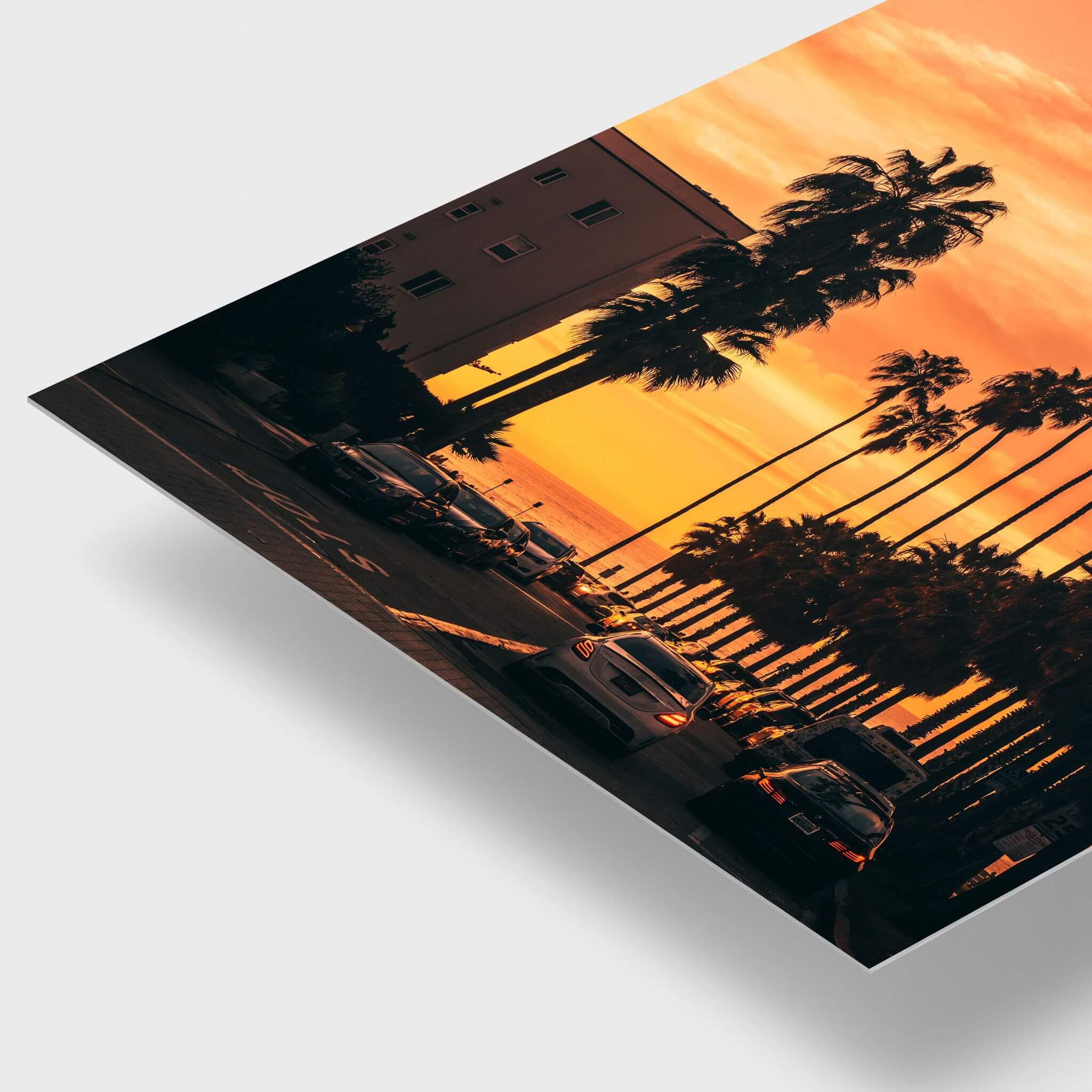 Close-up detail of Sizzling Hot San Diego Nights metal print showing vivid orange sunset tones, silhouetted palm trees and the sleek edge of the print.
