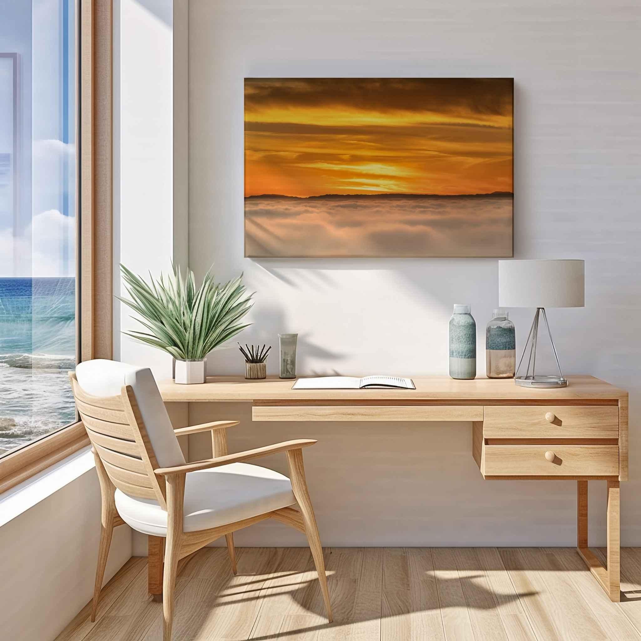 Soaring Above the Clouds gallery-wrapped canvas displayed above a wooden desk in a modern home office, featuring a golden winter sunset above a sea of clouds. Artwork by Abigail Diane Photography.