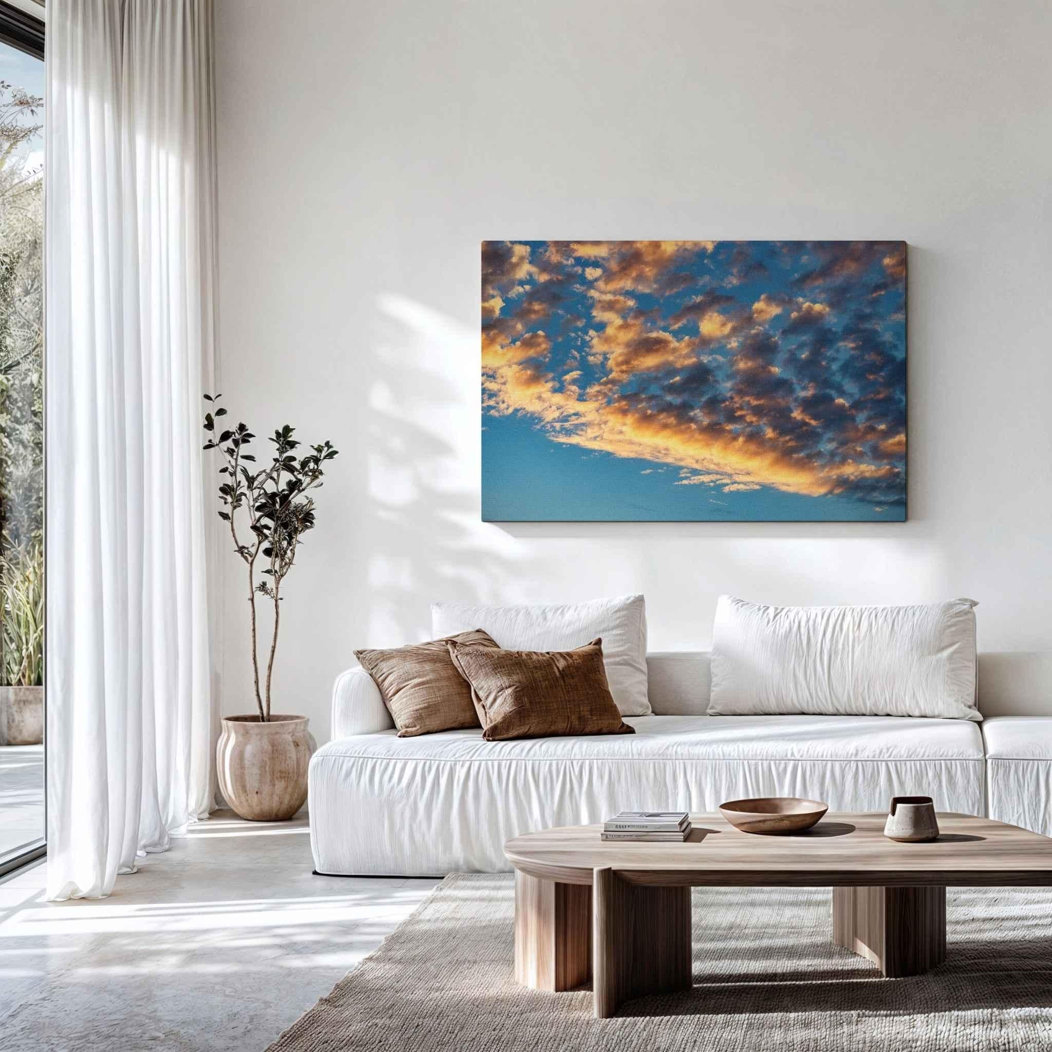 Golden cloudscape canvas wall art displayed in a modern living room, featuring illuminated clouds against a deep blue sky. Artwork by Abigail Diane Photography.