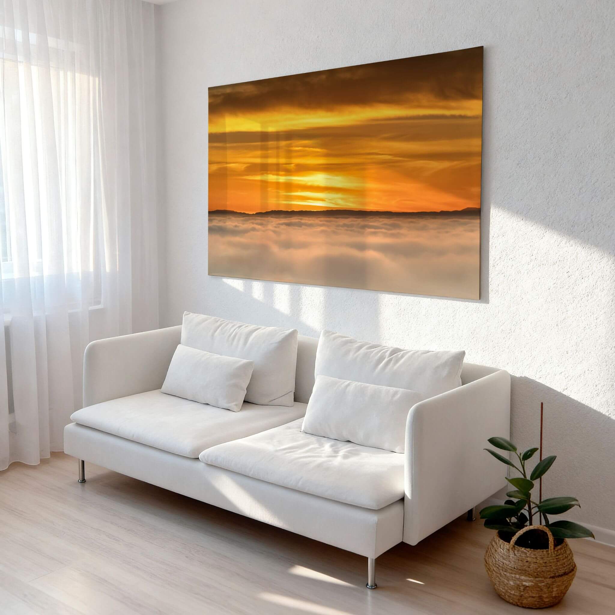 Large HD metal print of Soaring Above the Clouds by Abigail Diane Photography displayed above a contemporary white sofa, featuring a glowing golden sunset over clouds that creates a warm and tranquil focal point.