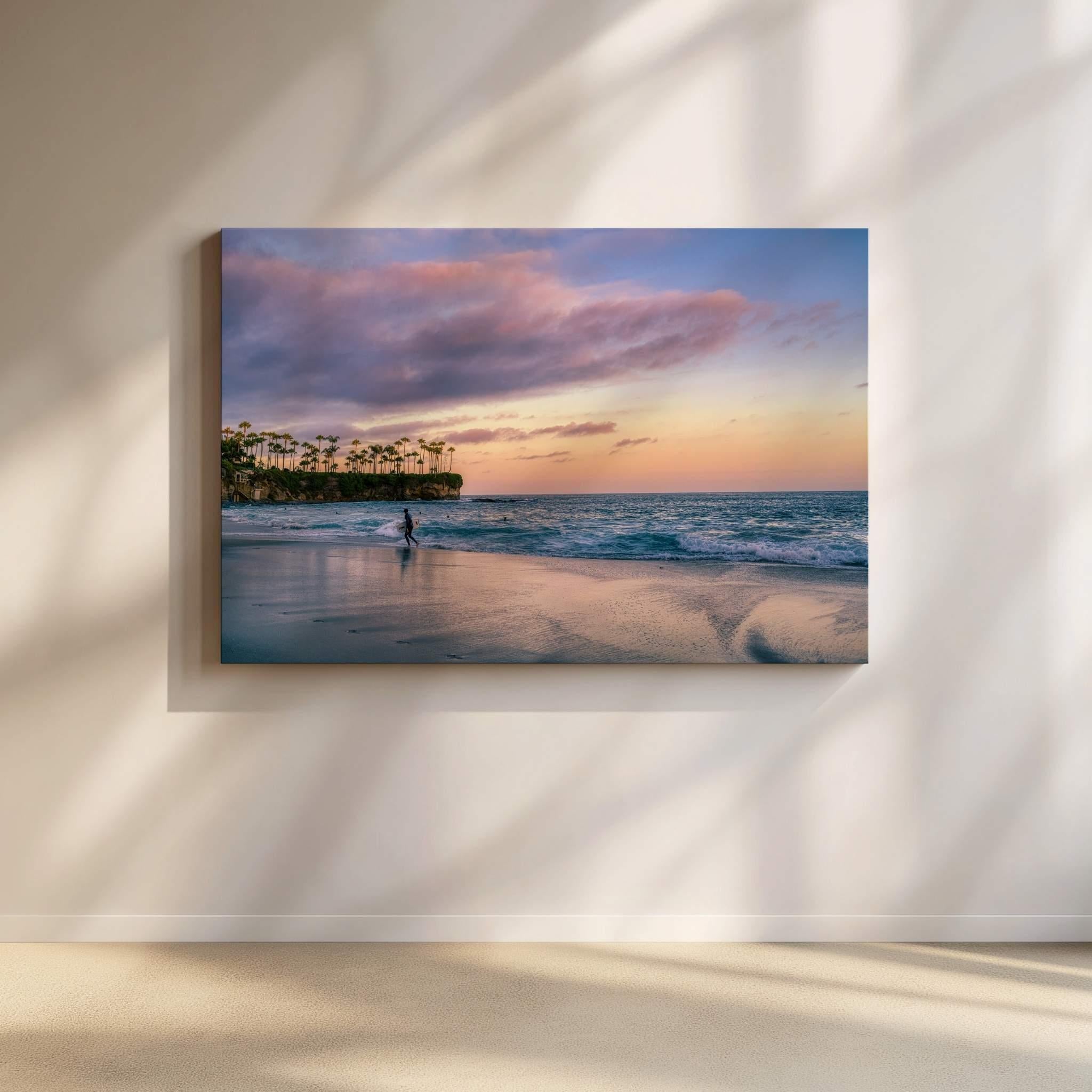 Surfing a California Sunset canvas print by Abigail Diane Photography displayed on a gallery wall, featuring a lone surfer beneath pastel sunset skies at Crescent Beach, Laguna Beach, California.