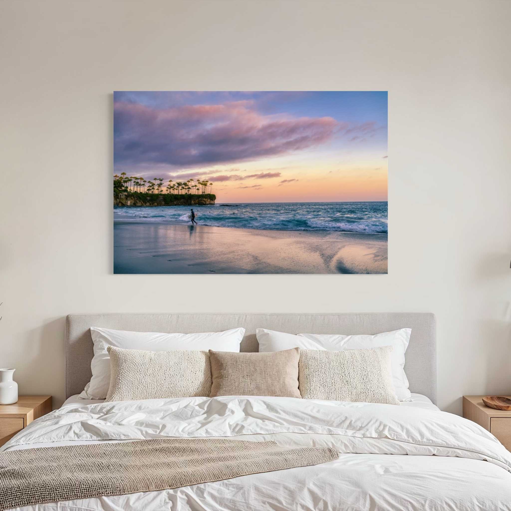 Surfing a California Sunset metal print displayed above a bed in a bright modern bedroom, featuring Crescent Beach, Laguna Beach, California. Artwork by Abigail Diane Photography.