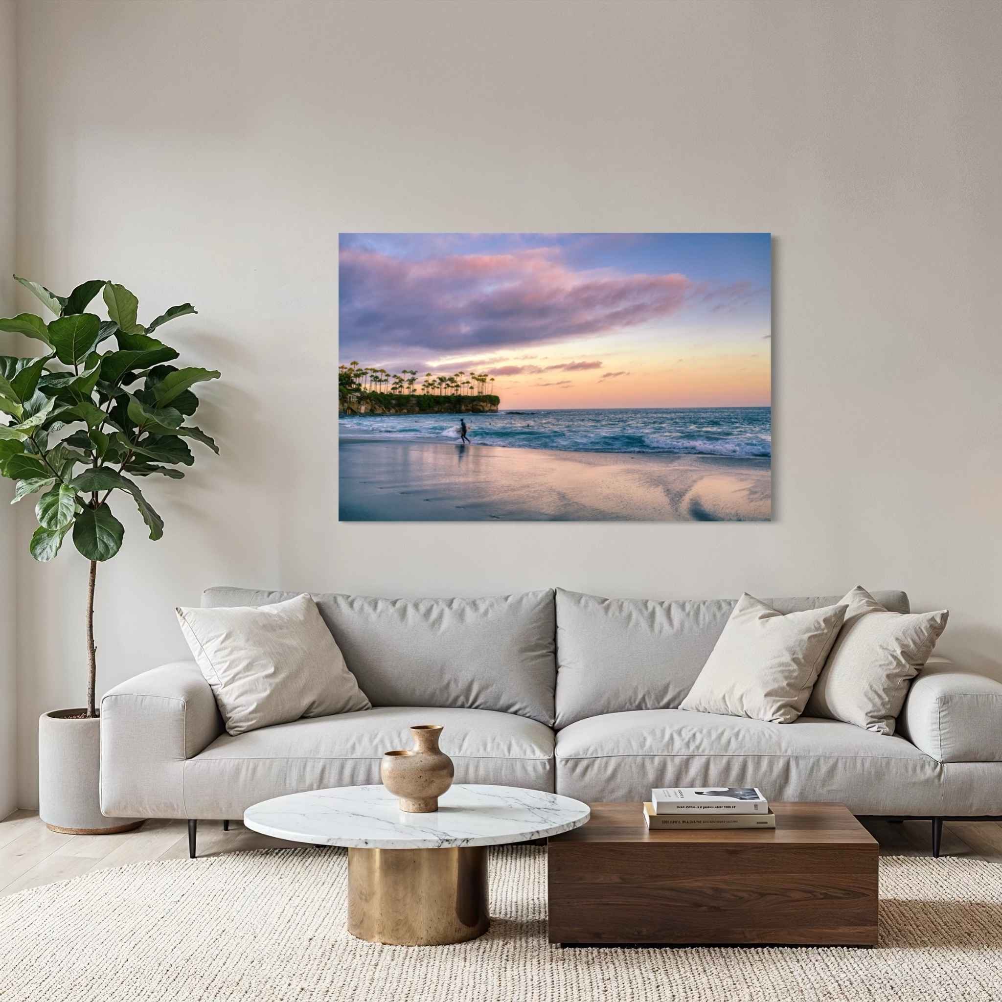 Surfing a California Sunset dye-sublimation metal print displayed above a contemporary sofa in a minimalist living room, featuring Crescent Beach, Laguna Beach, California. Artwork by Abigail Diane Photography.