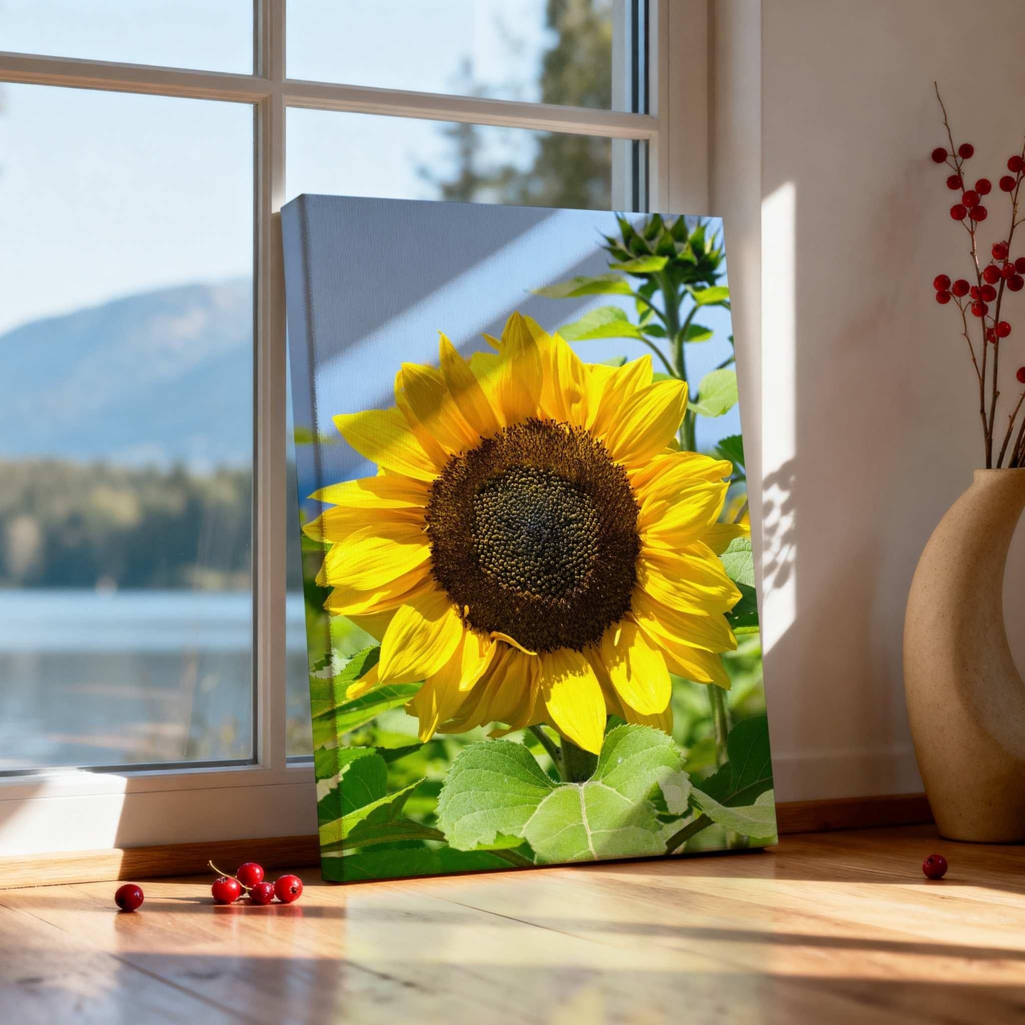 Turning Towards the Light sunflower canvas print by Abigail Diane Photography displayed beside a sunlit window overlooking a peaceful lake and mountain landscape.