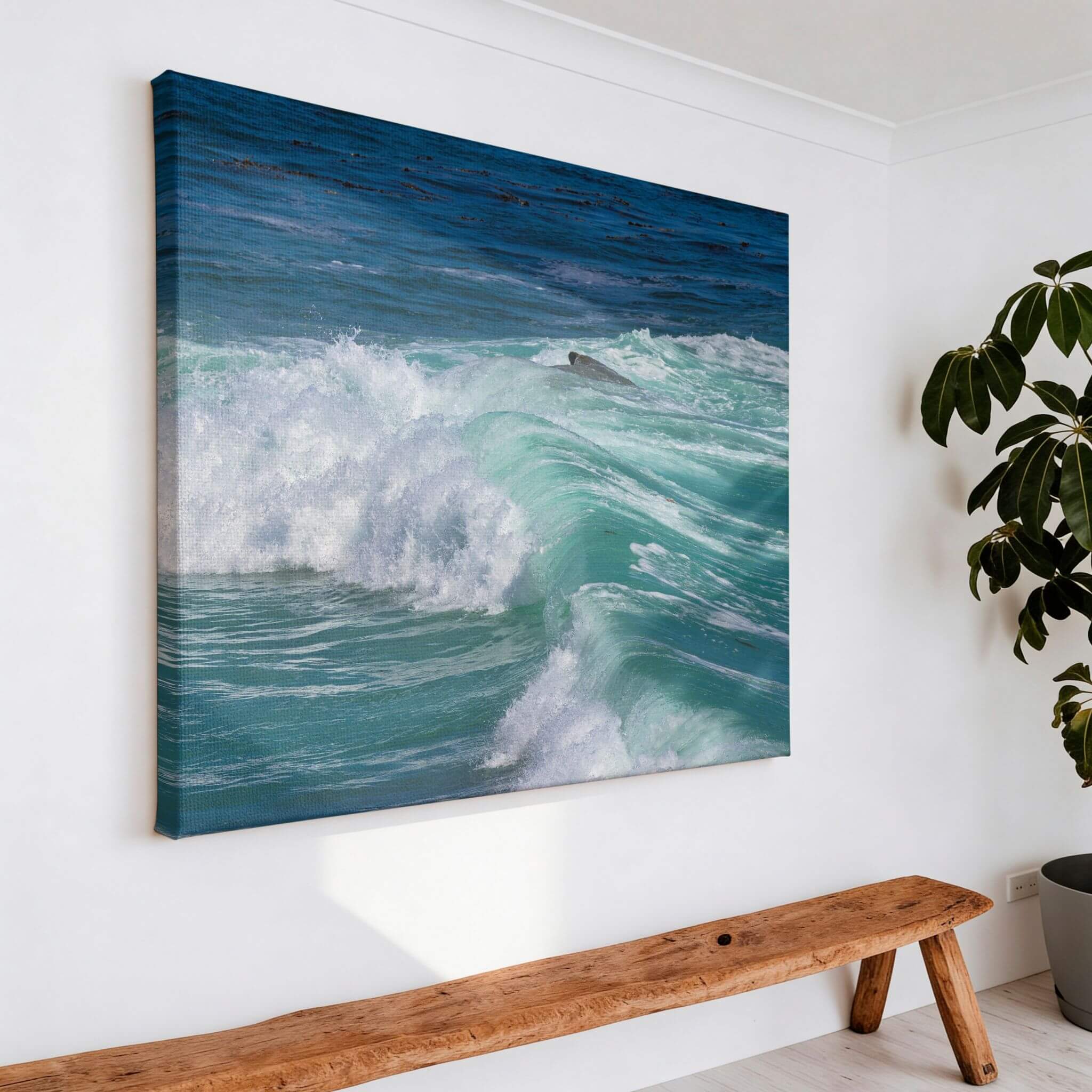 Large canvas print of Turquoise Healing Waves displayed above a rustic wood bench, featuring turquoise waves crashing along Laguna Beach on California's Pacific Ocean. Coastal nature wall art by Abigail Diane Photography.