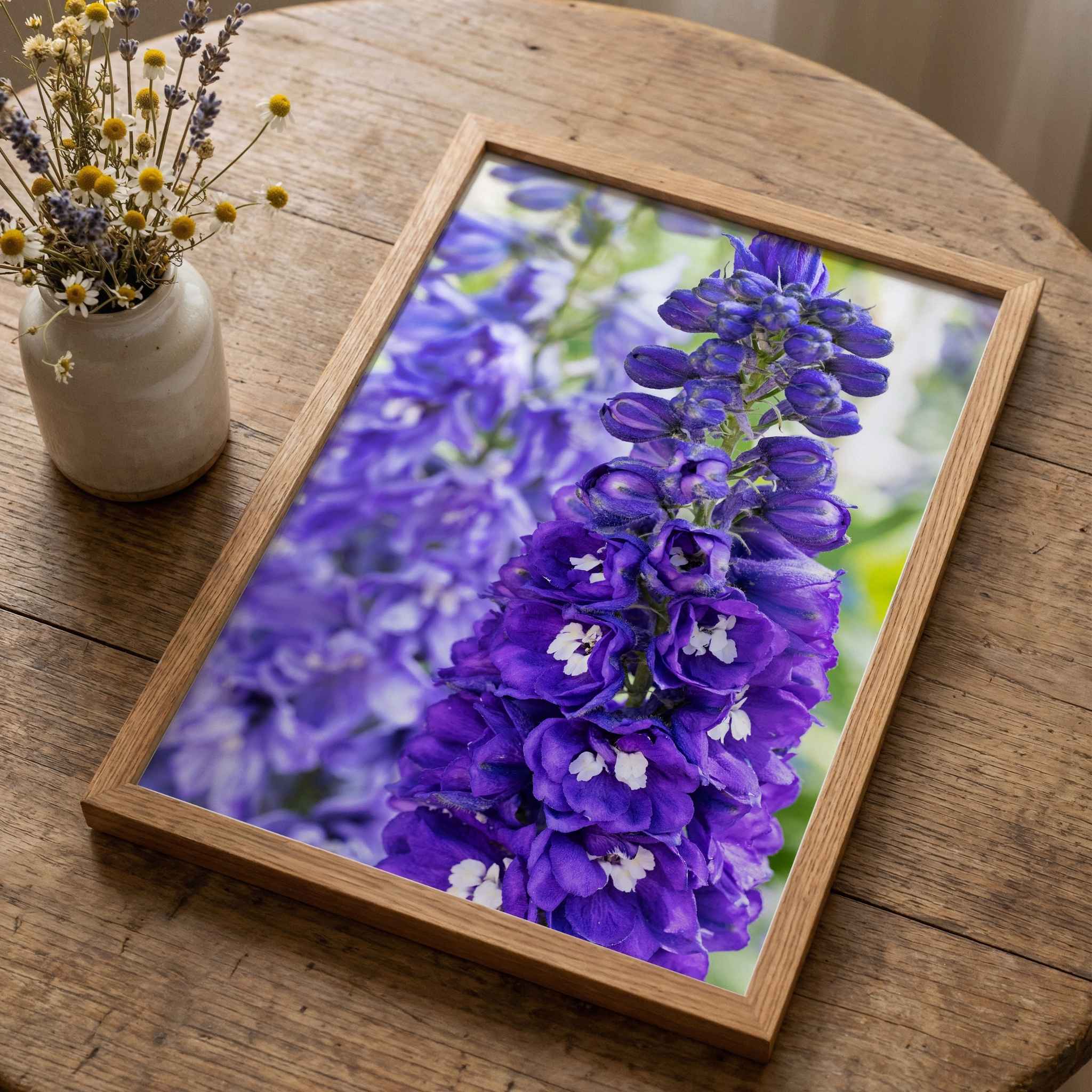 Violet Harmony purple larkspur framed fine art print in a natural wood frame displayed on a rustic wooden table by Abigail Diane Photography.