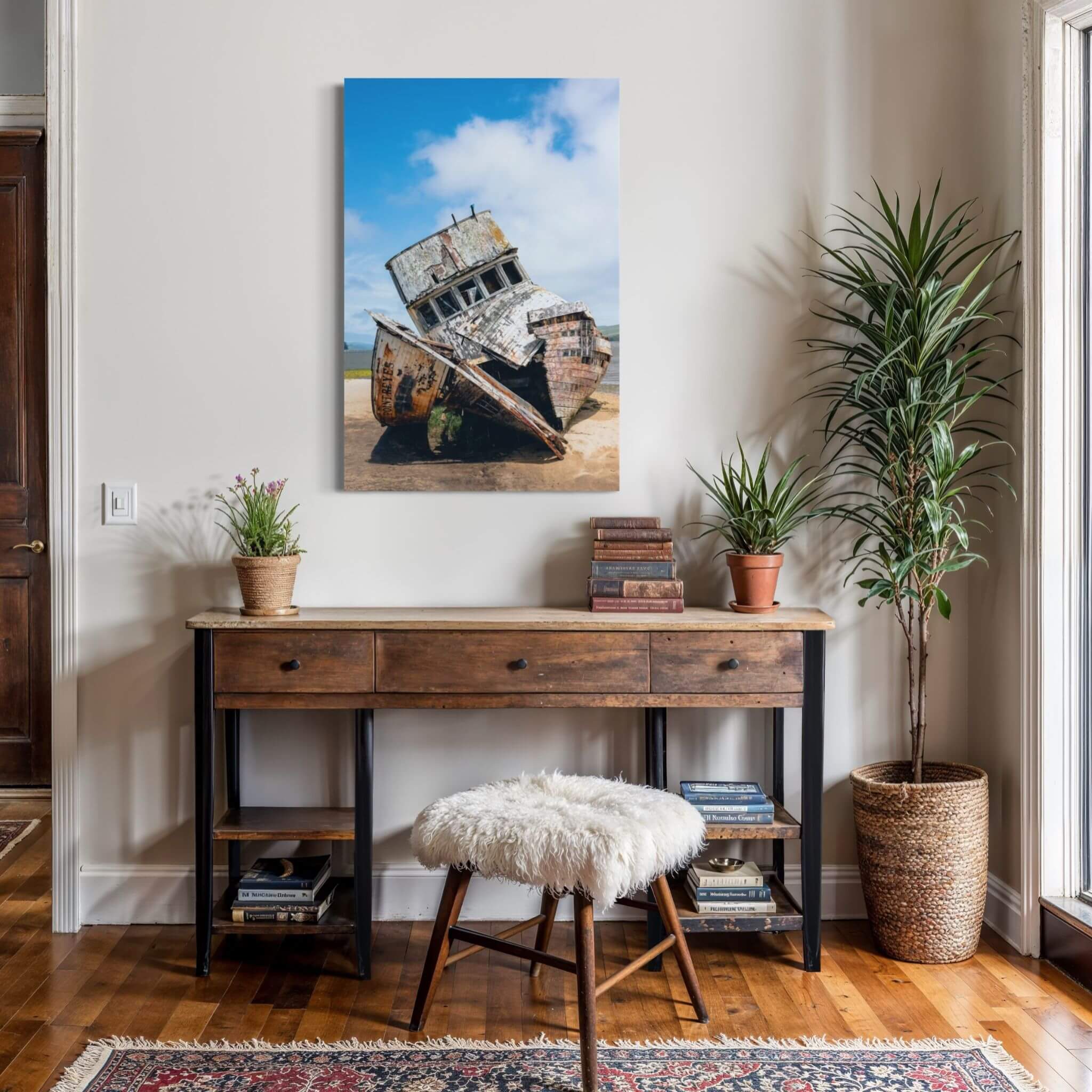 Weathered Echoes Point Reyes shipwreck metal print displayed above a rustic wood console in a warm entryway with plants and natural textures.