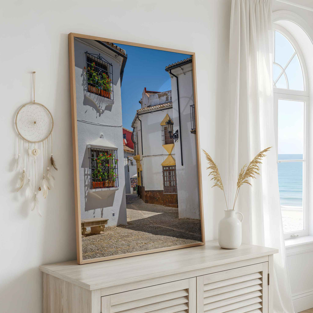 Whitewashed Streets of Setenil framed wall art displayed above a cabinet in a bright neutral interior – Abigail Diane Photography.