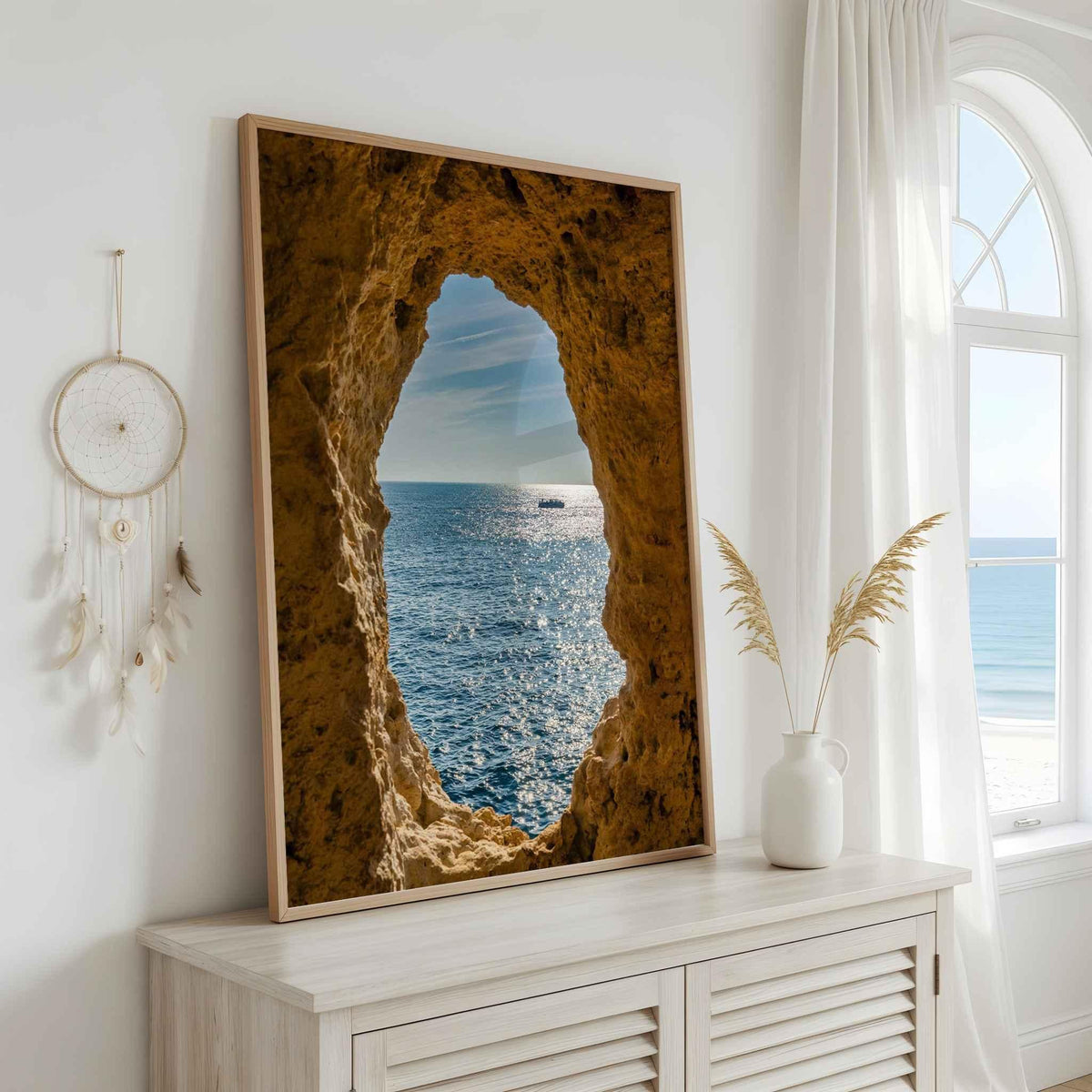 Window to the Atlantic fine art print of Algar Seco, Algarve, Portugal, displayed above a white console in a bright coastal interior.
