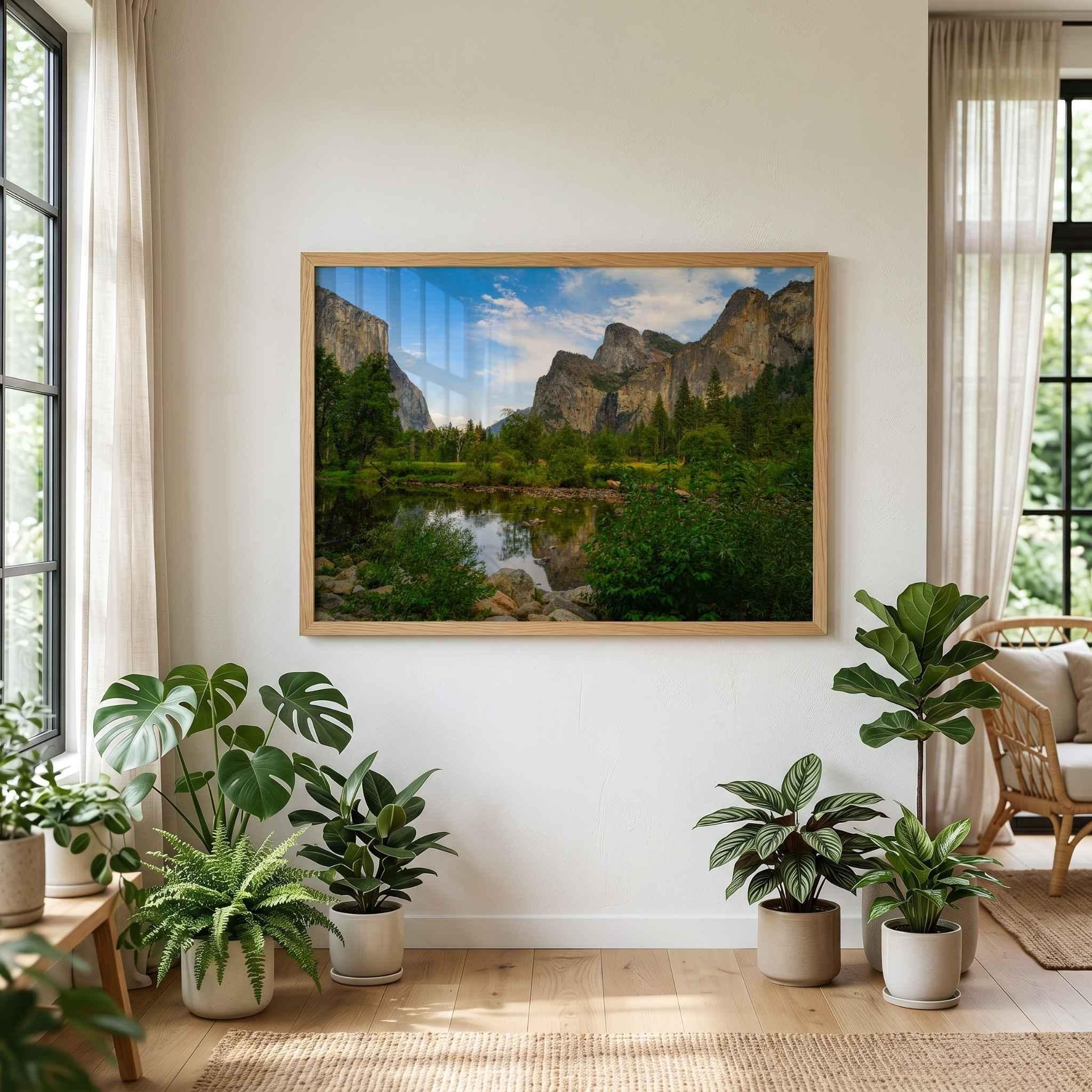 Oak-framed Yosemite Valley fine art print by Abigail Diane Photography displayed on a white wall above indoor plants in a bright botanical-inspired living room with natural wood flooring and soft daylight.