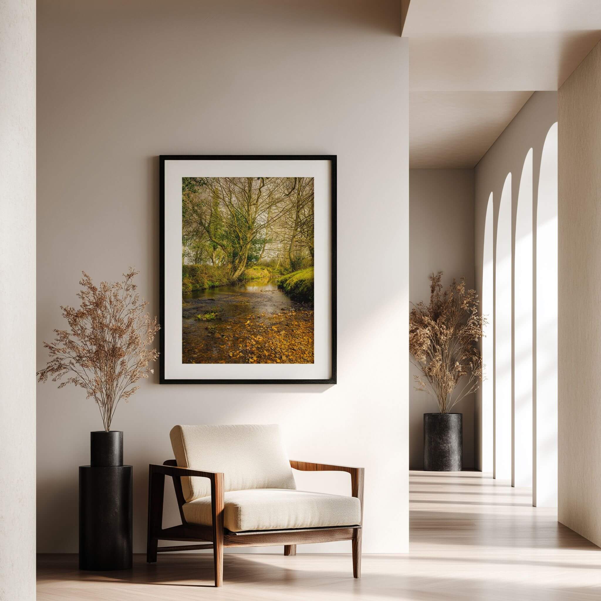 A Lazy Creek in the New Forest fine art print displayed in a black frame with white matting in a softly lit neutral interior.