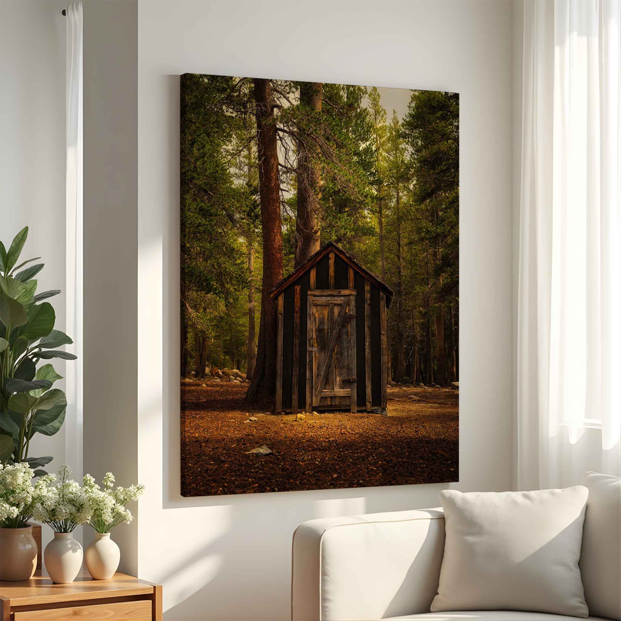Rustic-remnant among the trees in a  archival giclée gallery-wrapped canvas featuring a rustic wooden outhouse surrounded by forest at Mammoth in the Eastern Sierras, California, displayed in a bright neutral living room.