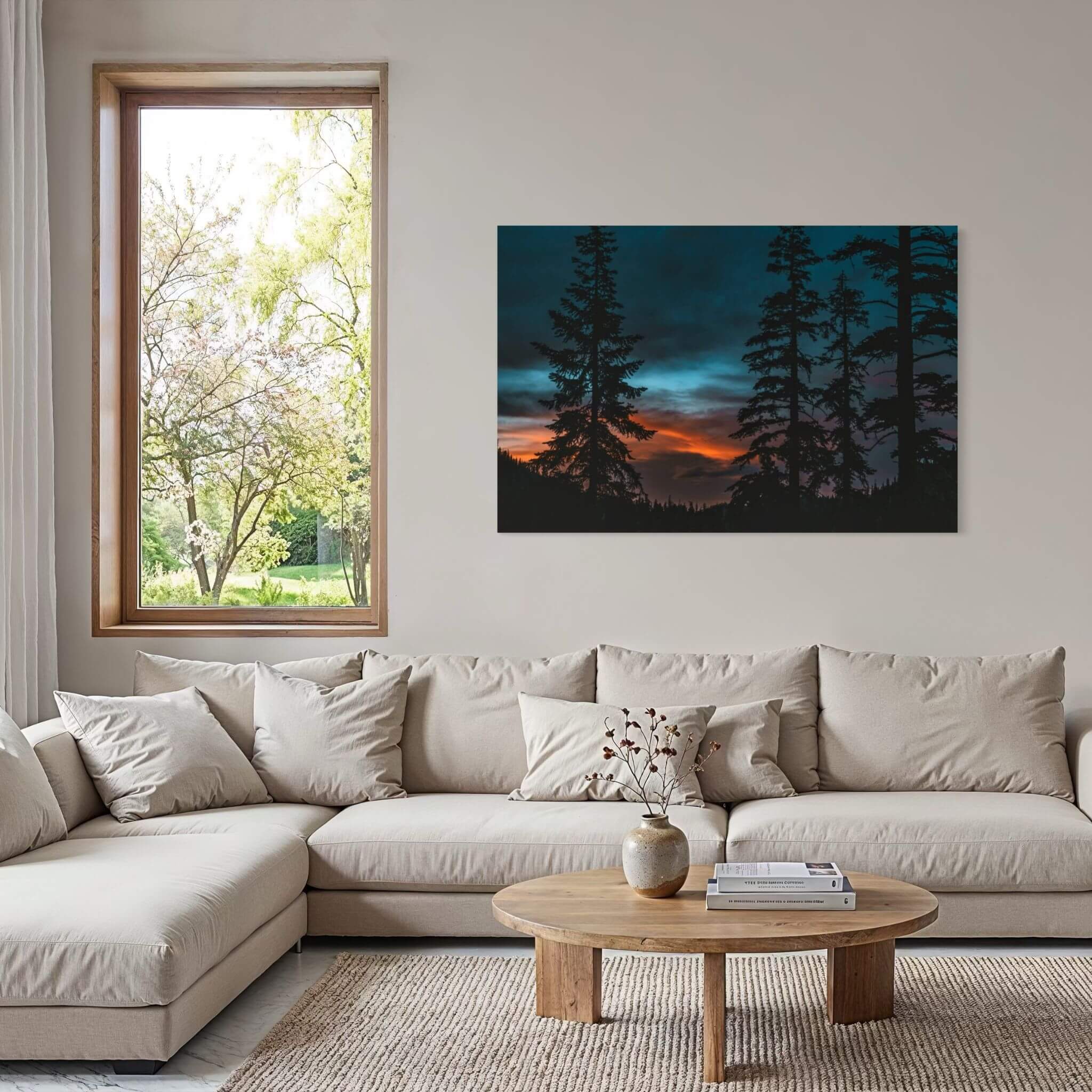 Blue Hour Among the Pines forest sunset wall art displayed above a neutral sectional sofa in a contemporary living room with natural wood accents.