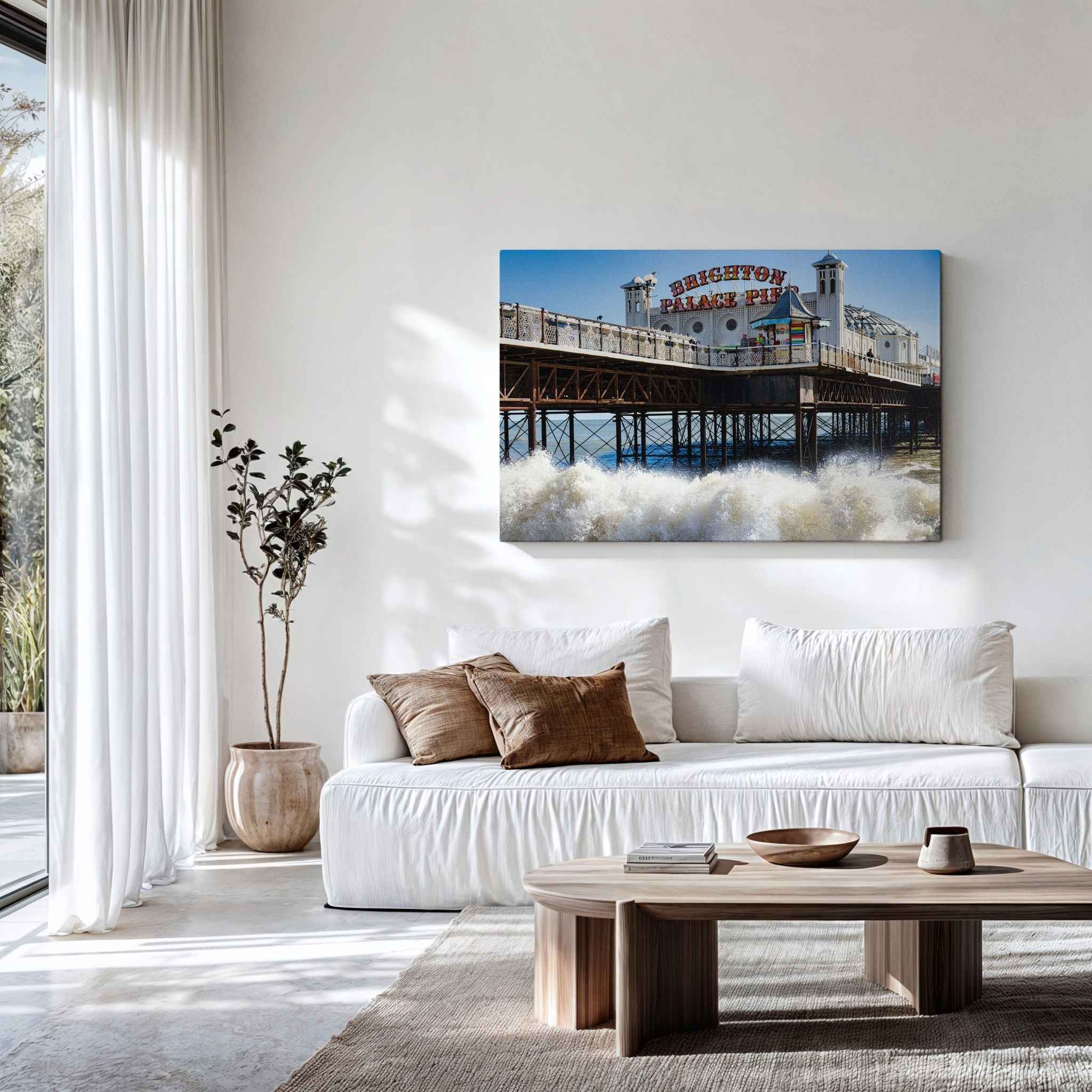 Brighton Palace Pier canvas wall art displayed above a white sofa in a modern coastal living room featuring the iconic Victorian pier and crashing waves.