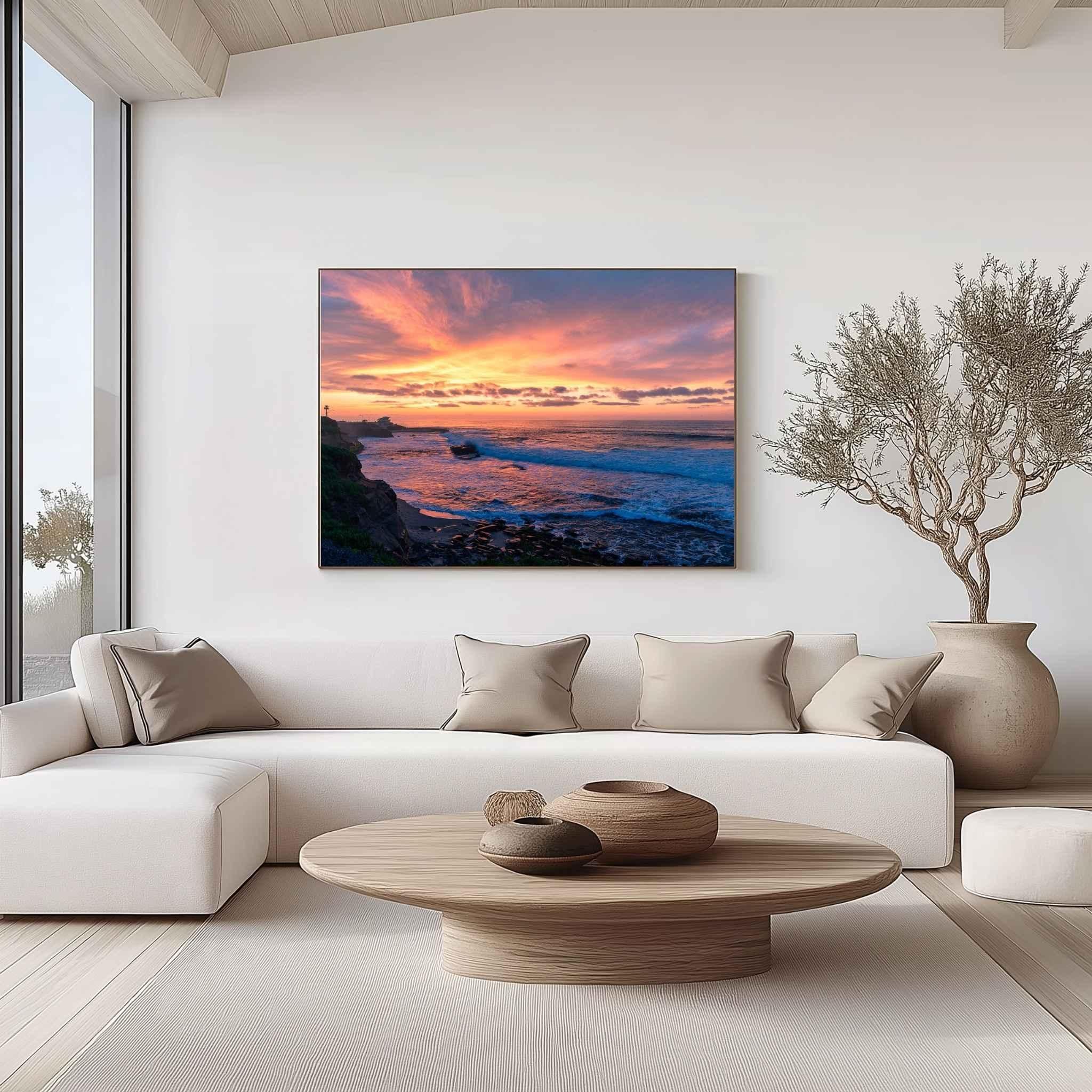 Gallery-wrapped canvas of Candy Floss Sunset displayed above a contemporary cream sofa in a minimalist living room, featuring a pastel winter sunset over the Pacific Ocean in La Jolla, California. Fine art canvas wall décor by Abigail Diane Photography.