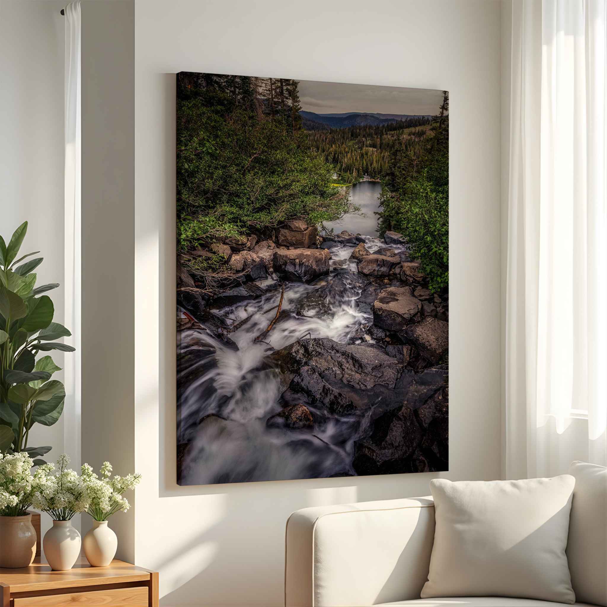 Cascading Into Stillness archival giclée canvas featuring cascading mountain water flowing toward a peaceful lake in the Eastern Sierra, California, displayed in a bright neutral living room.
