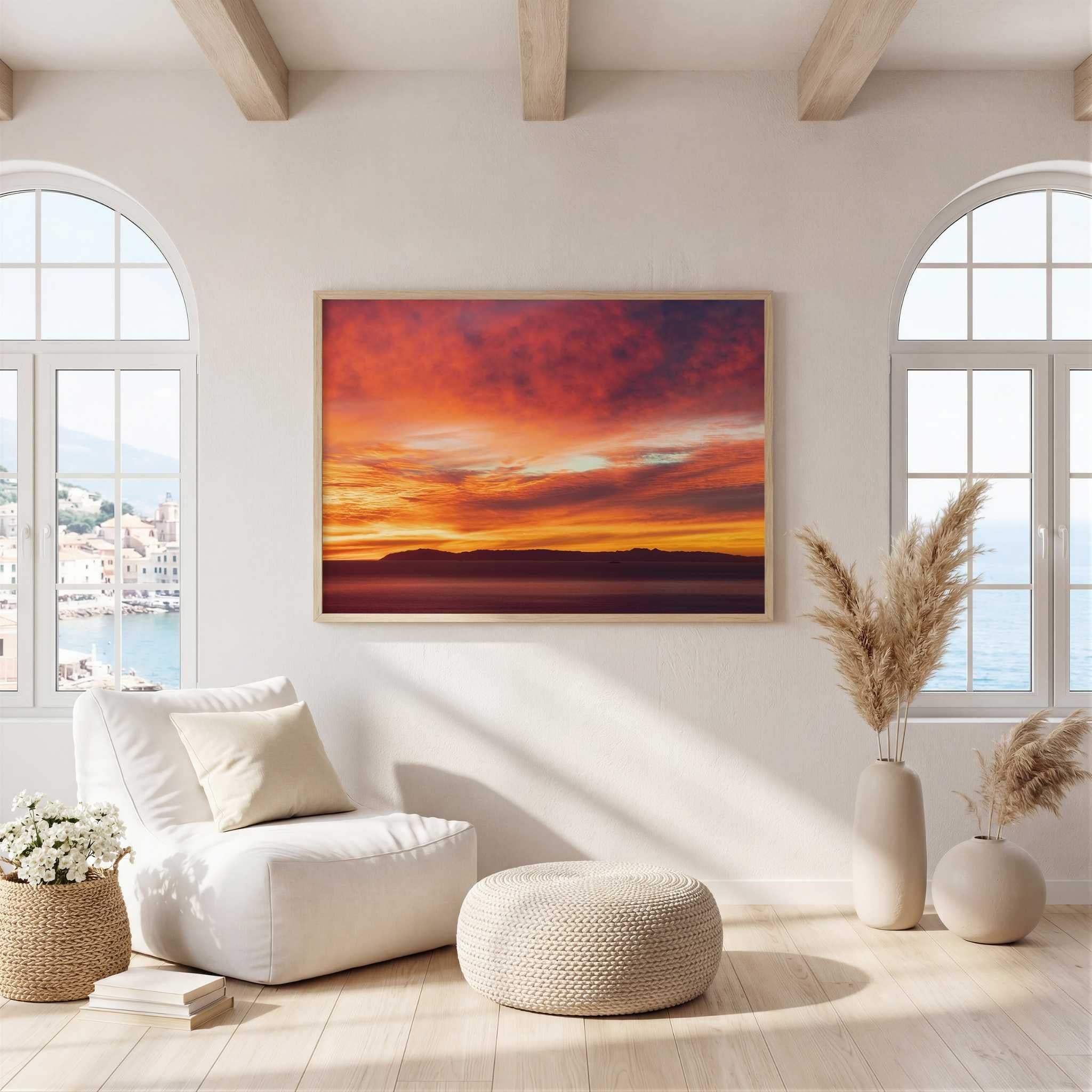 Catalina Beneath Crimson Skies fine art print by Abigail Diane Photography displayed in a bright modern coastal living room above a lounge chair with warm neutral décor and views of the ocean.