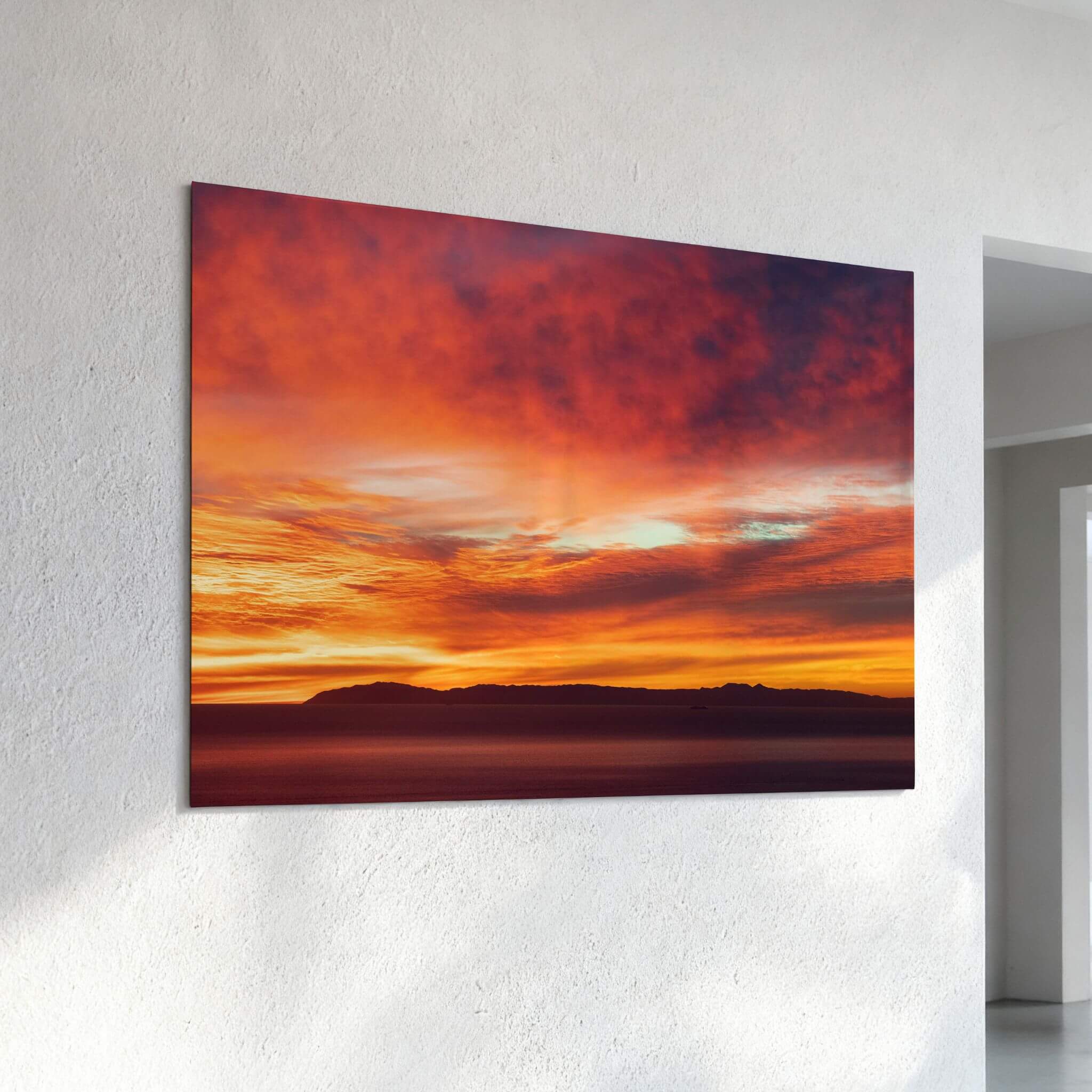 Catalina Beneath Crimson Skies metal wall art displayed on a textured white wall, featuring a dramatic California sunset over Catalina Island.