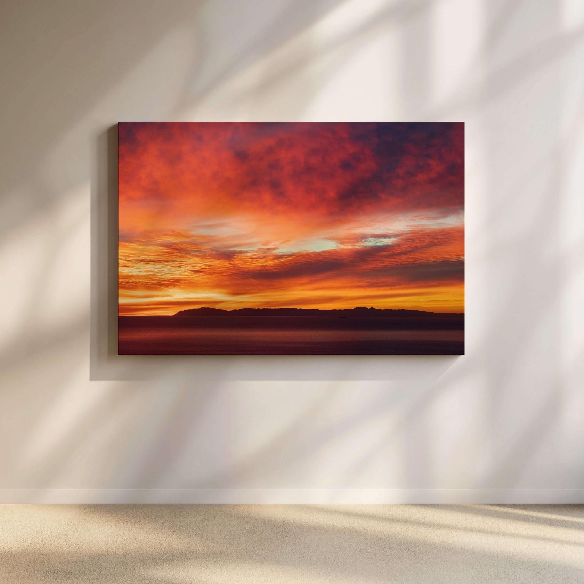 Catalina Beneath Crimson Skies sunset wall art featuring the silhouette of Catalina Island beneath dramatic crimson, orange, and gold clouds over the Pacific Ocean. This fine art landscape photograph captures a vibrant California sunset with rich colors and tranquil coastal beauty by Abigail Diane Photography.