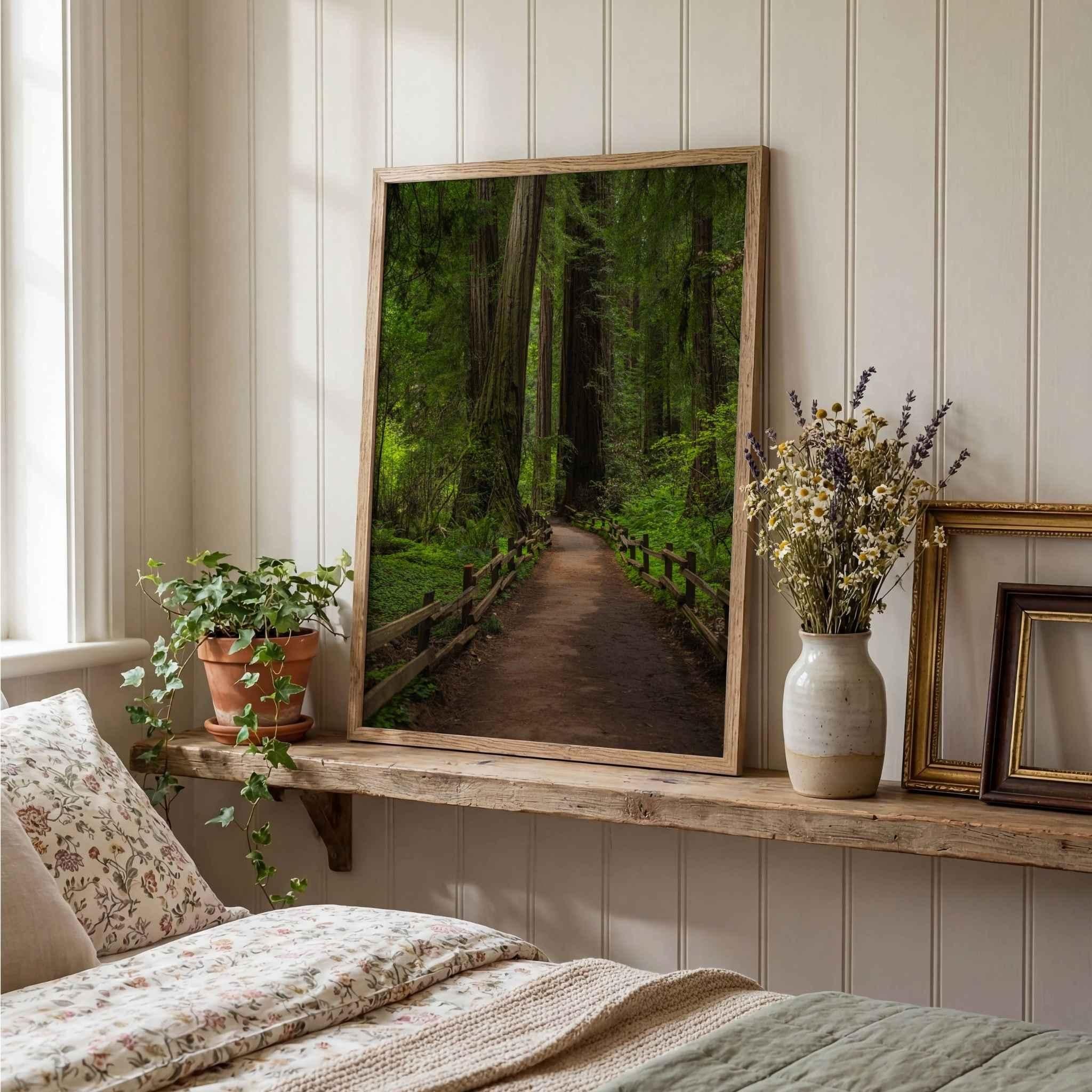 Cathedral of Giants fine art photograph by Abigail Diane Photography displayed in a cozy bedroom with a natural oak frame, featuring a forest path winding through towering redwood trees in Muir Woods, California.