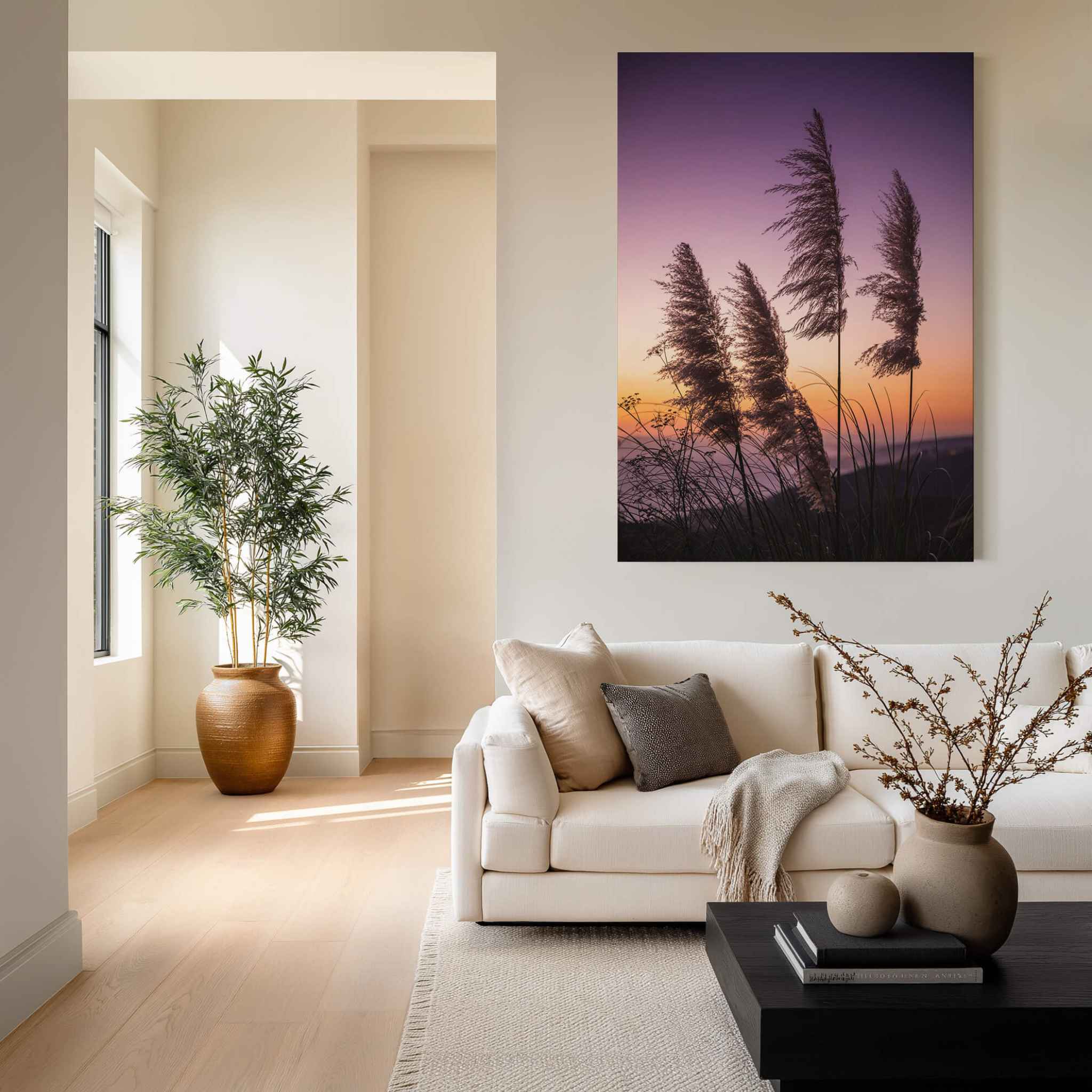 Coastal Pampas Grass Sunset Laguna Beach metal wall art displayed above a neutral sofa in a warm contemporary living room, featuring purple, pink and golden California sunset skies.