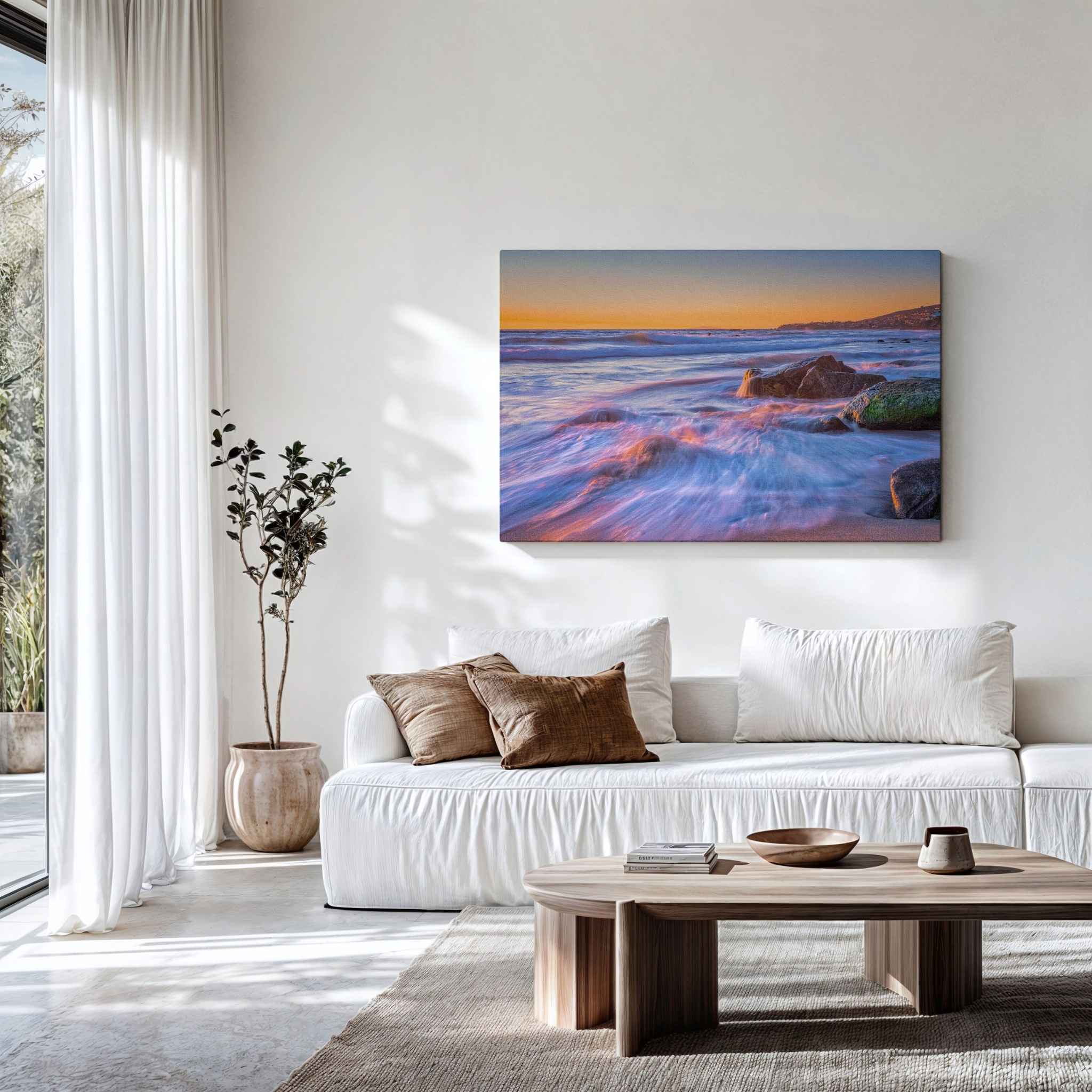 Gallery wrapped canvas of Cotton Candy Waves displayed above a modern white sofa, featuring flowing pastel waves at sunset along the Laguna Beach coastline, California. Fine art wall decor by Abigail Diane Photography.