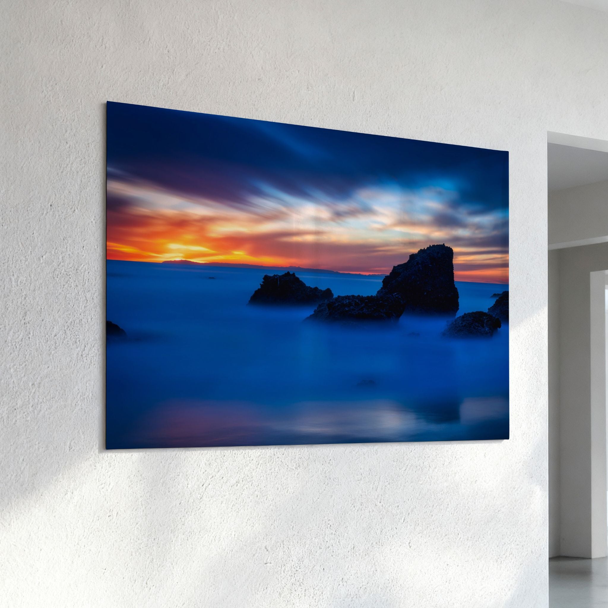 Escape to a Mystical Blue Hour high-definition metal print mounted on a textured wall, featuring a peaceful blue-hour sunset with vibrant orange skies, silhouetted sea stacks, and silky Pacific Ocean water at Laguna Beach, California.